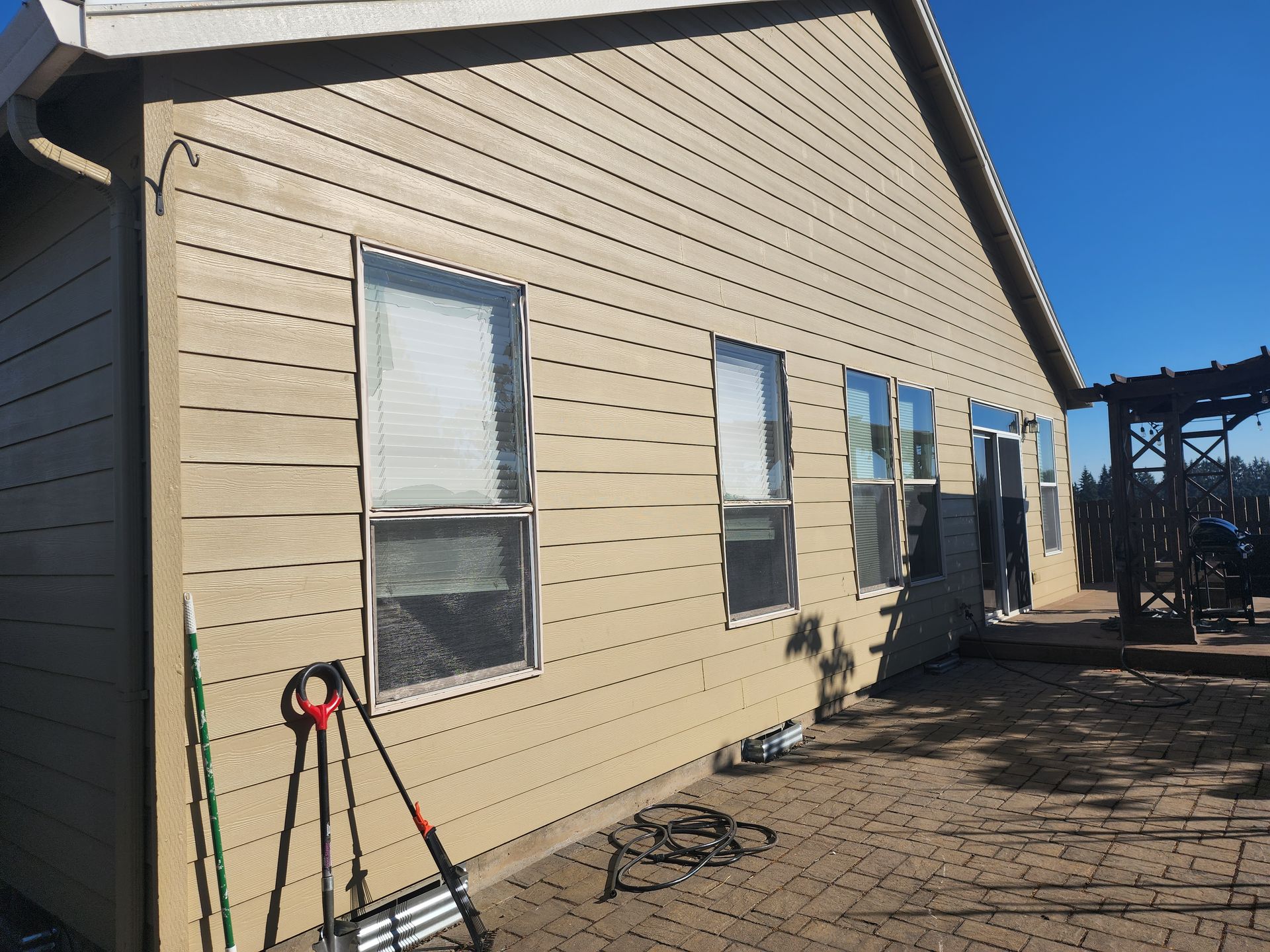 A house with a lot of windows and a ladder in front of it