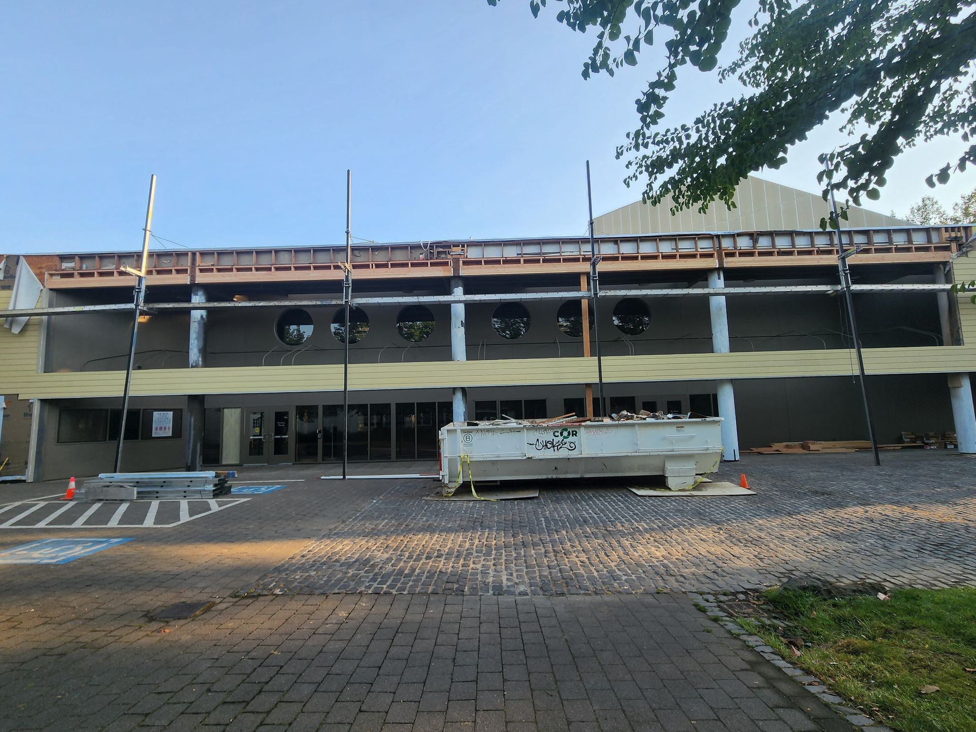 A large building under construction with a handicapped parking spot in front of it