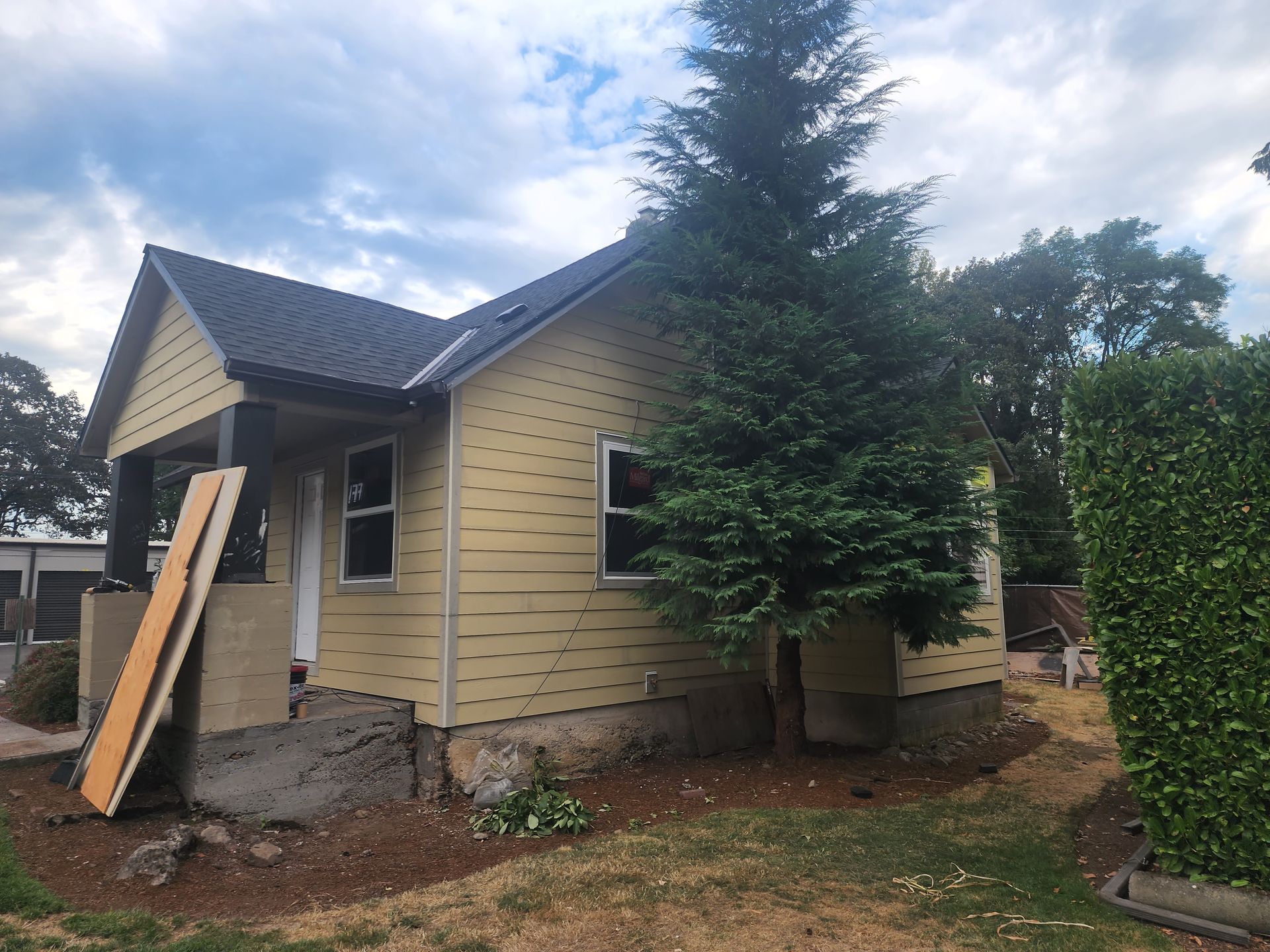A small house with a tree in front of it
