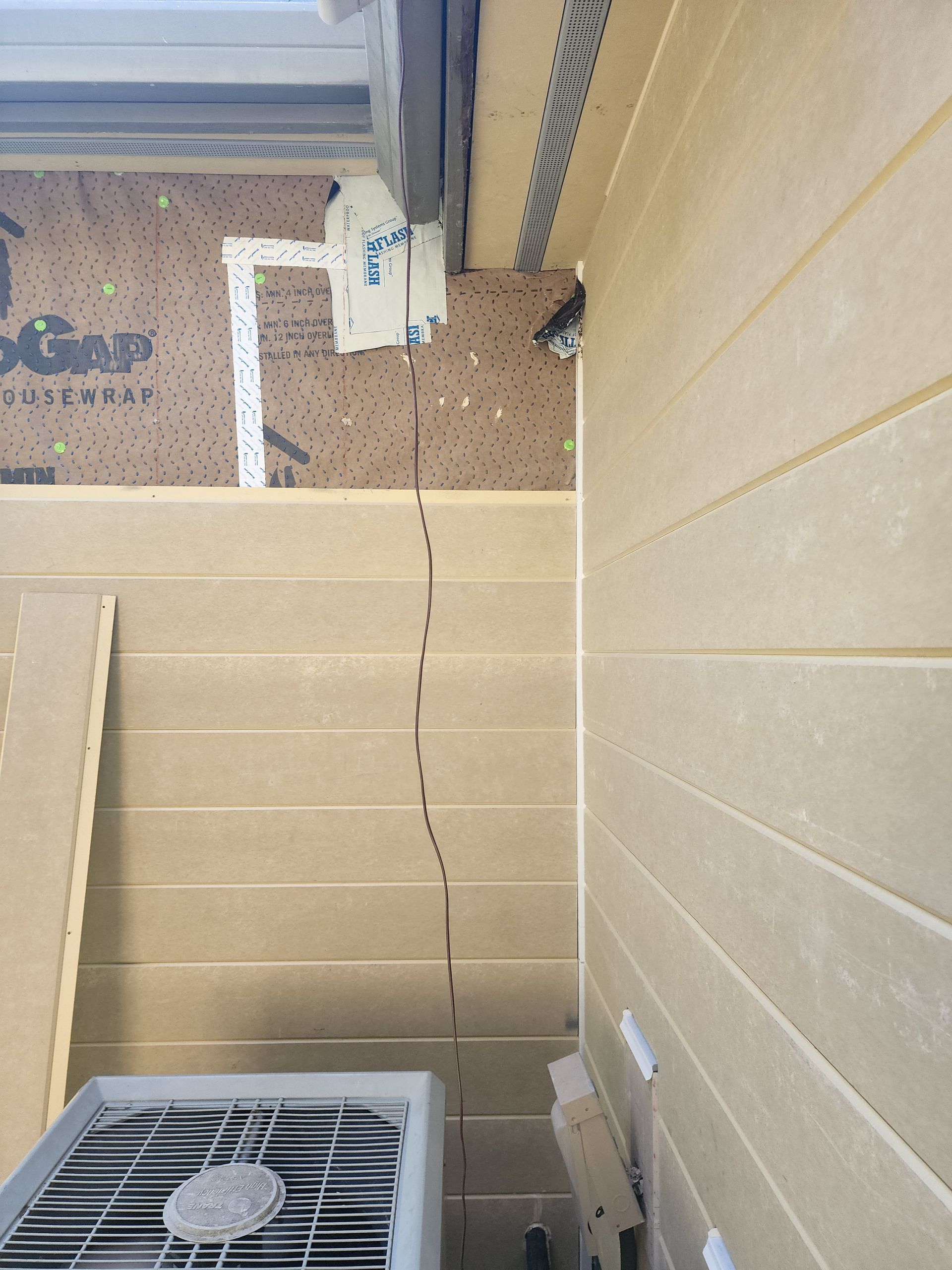 An air conditioner is sitting on the side of a building