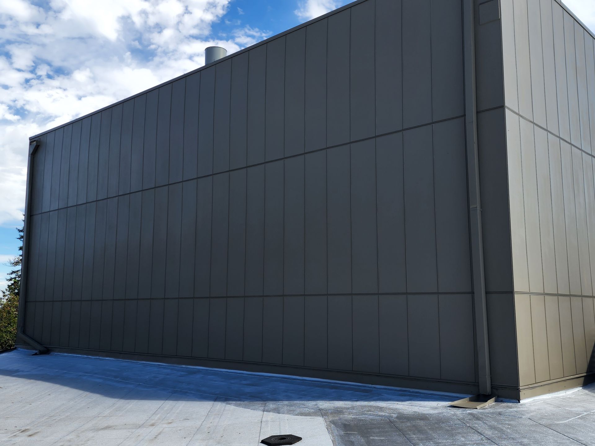 A large gray building with a blue sky in the background