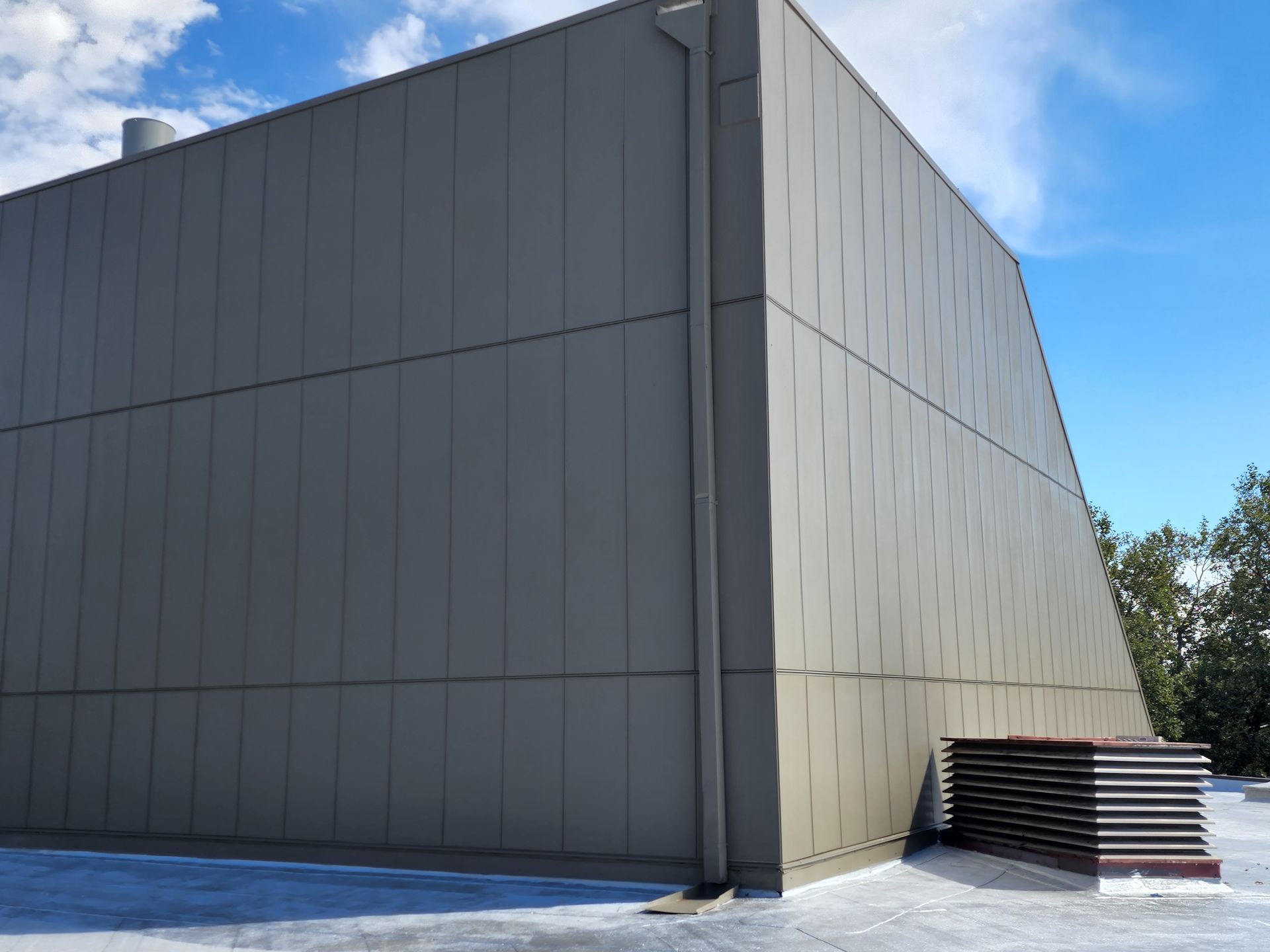 A large building with a lot of windows and a drainpipe on the side of it.