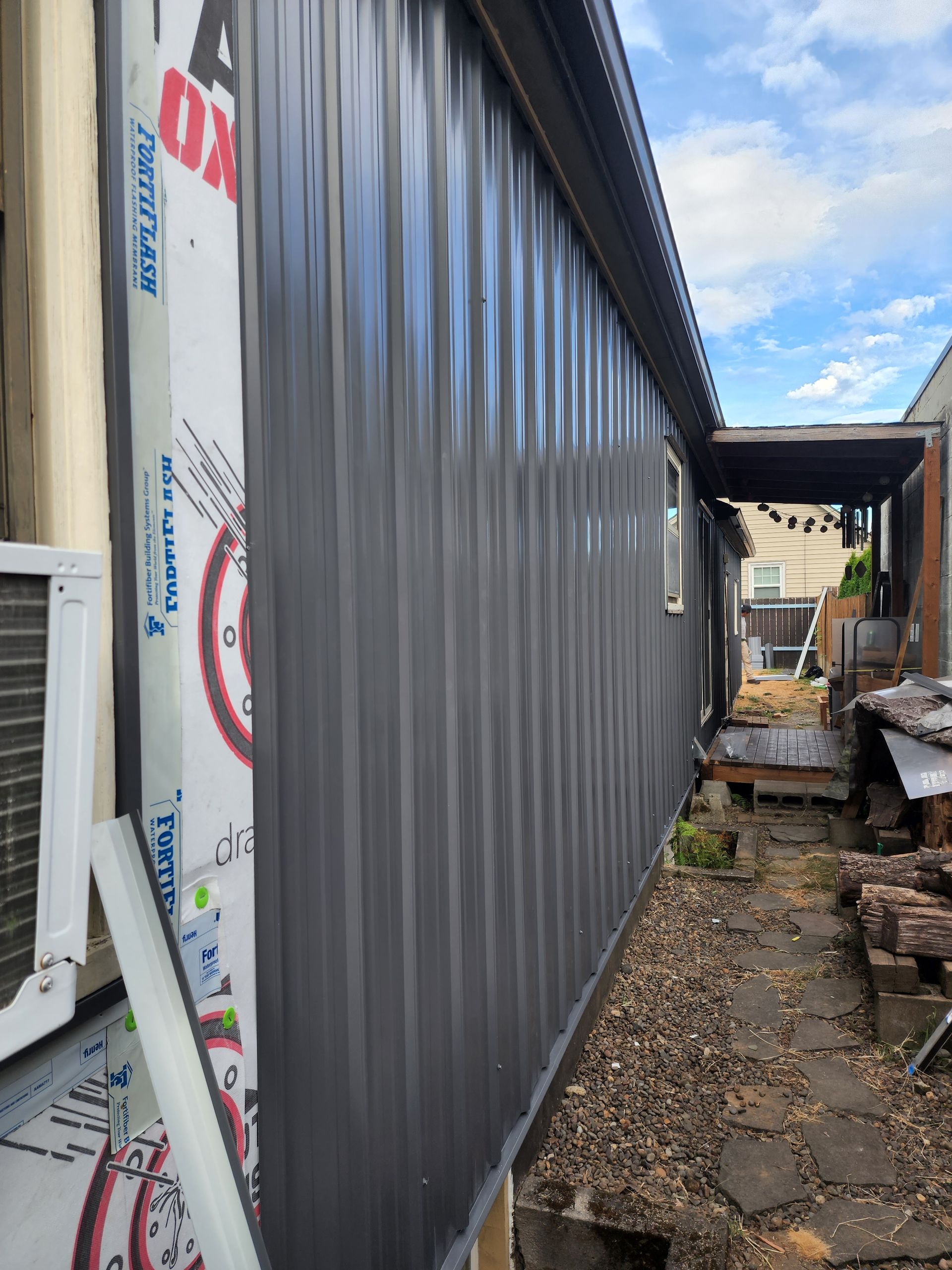 The side of a building with a gray siding and a window.