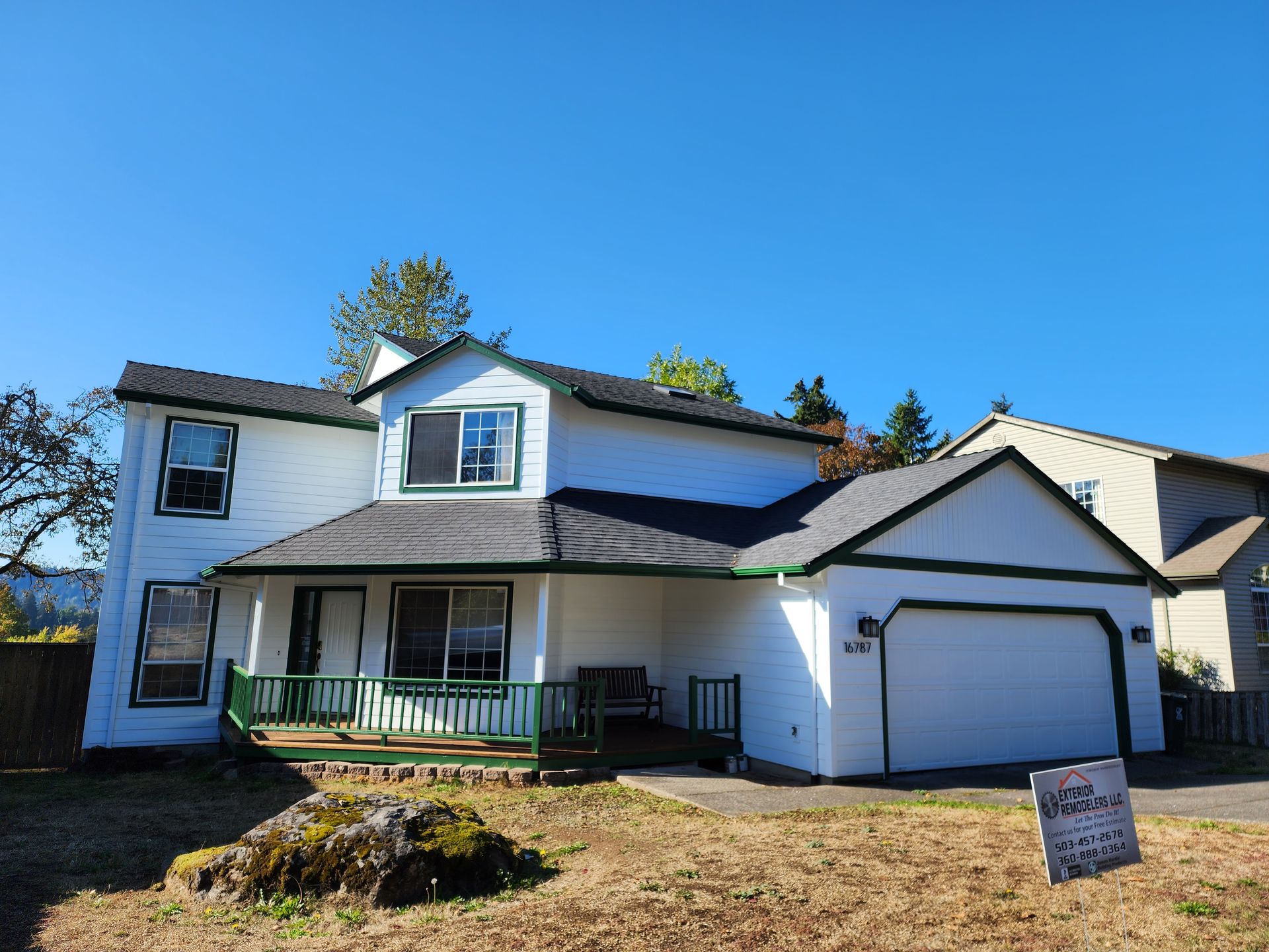 A yellow house with a deck and stairs in front of it.