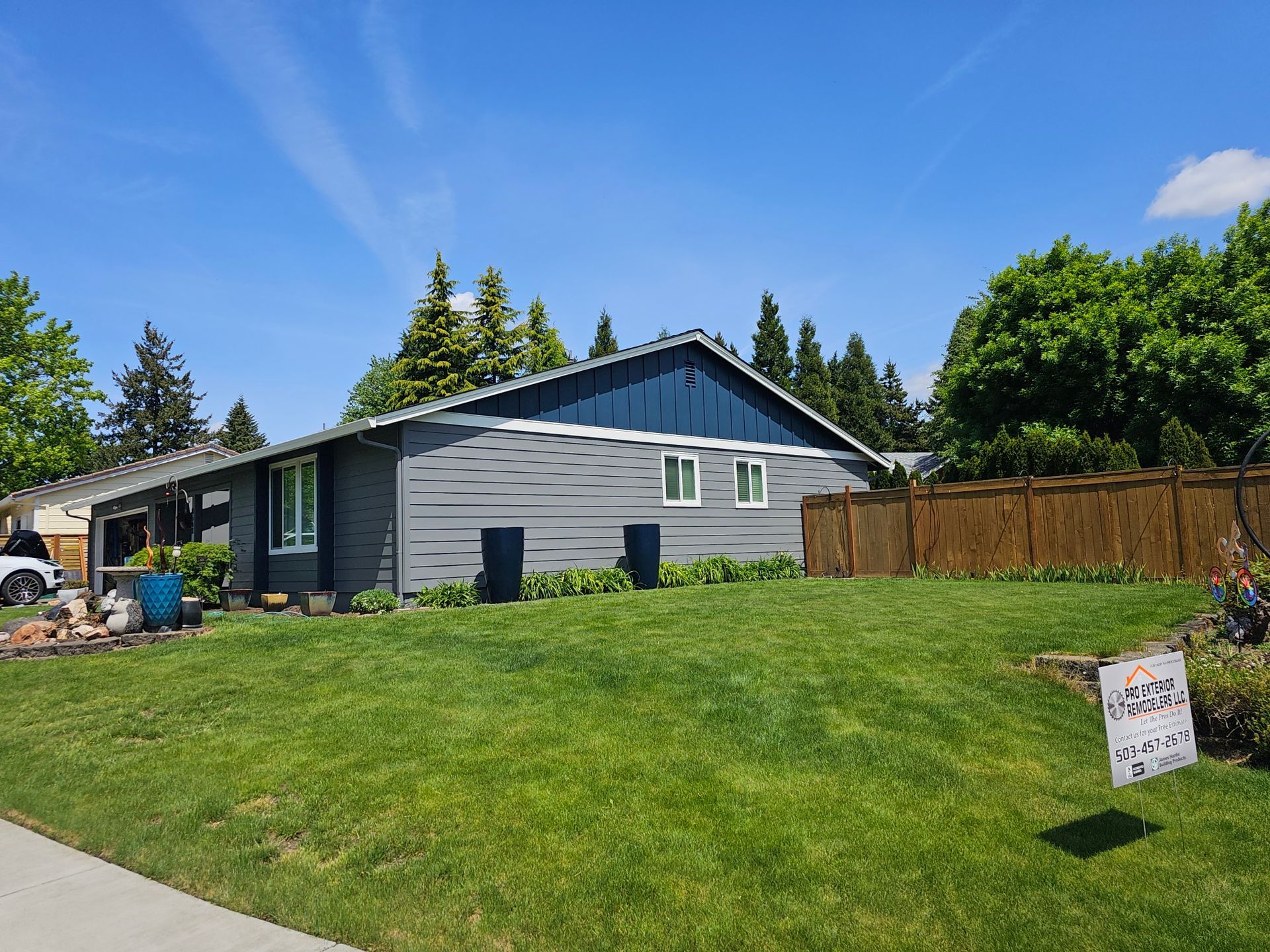 A blue house with a fence in front of it.