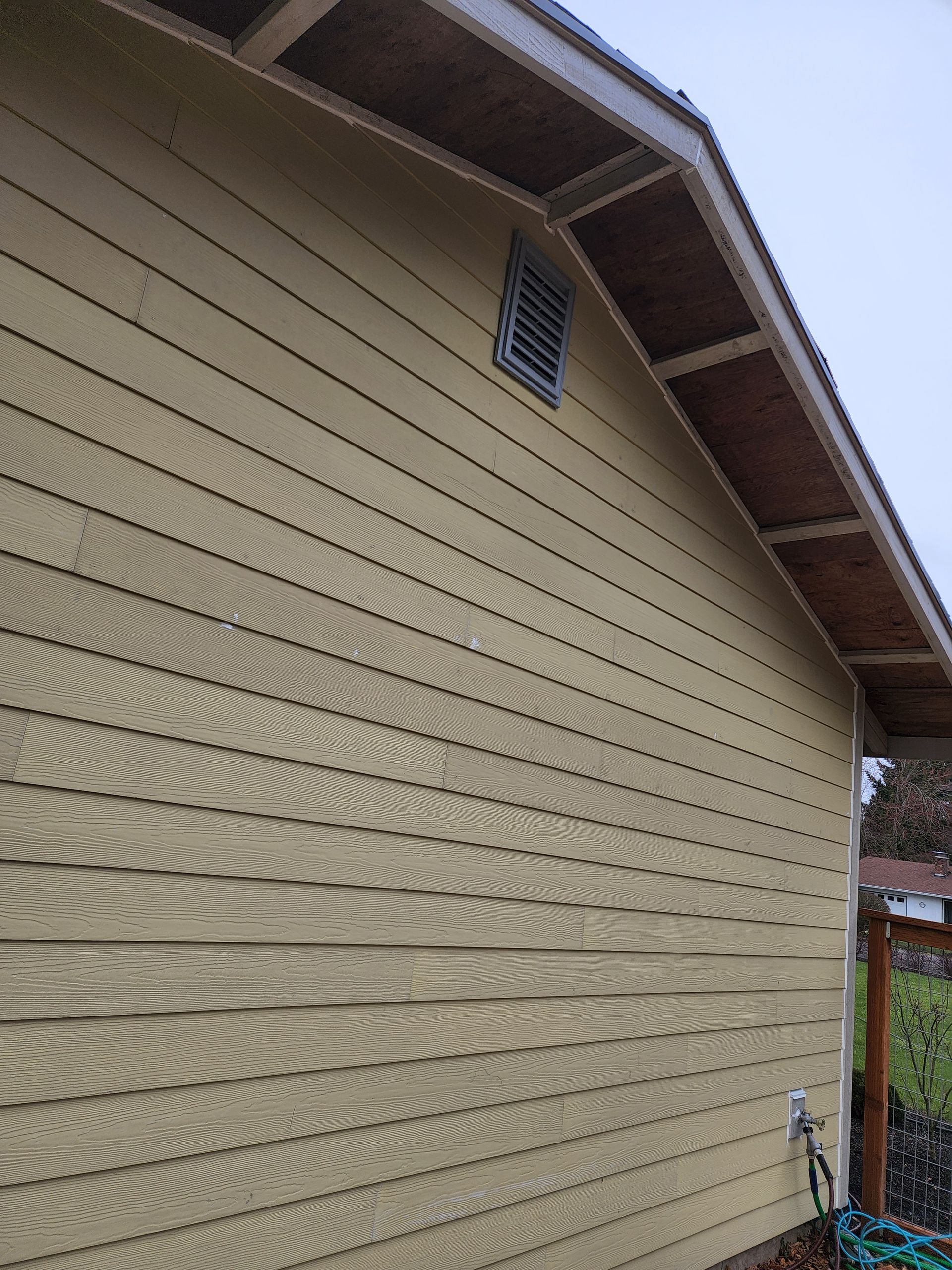 A yellow house with a wooden roof and siding.
