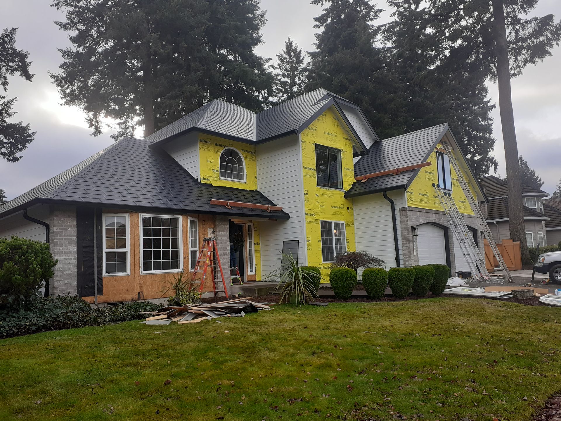 A large house with a yellow roof is being built.