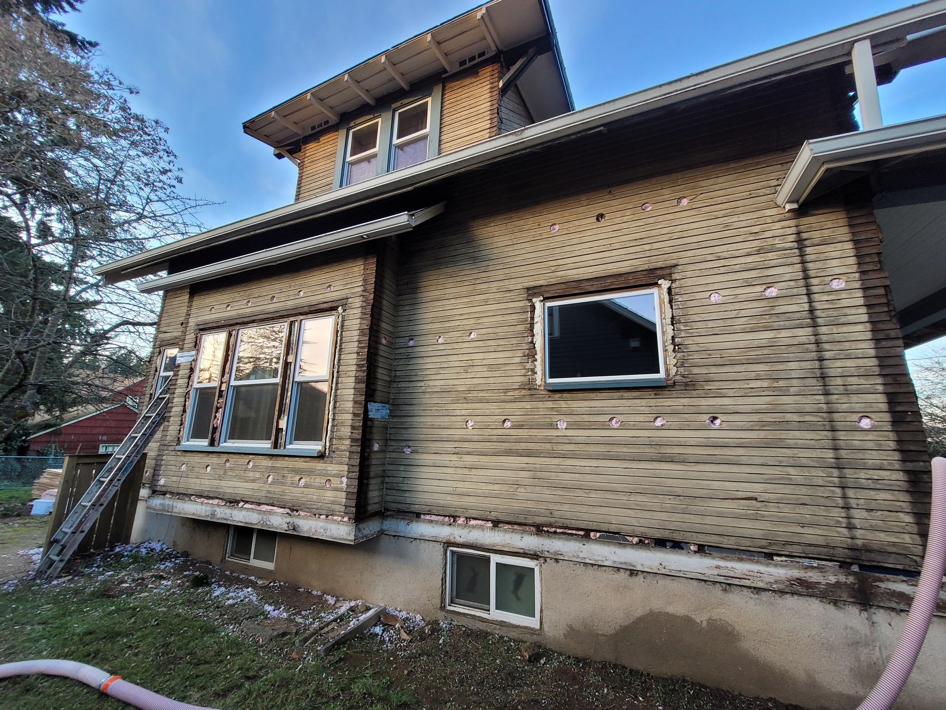 A house with a lot of windows and a hose in front of it.