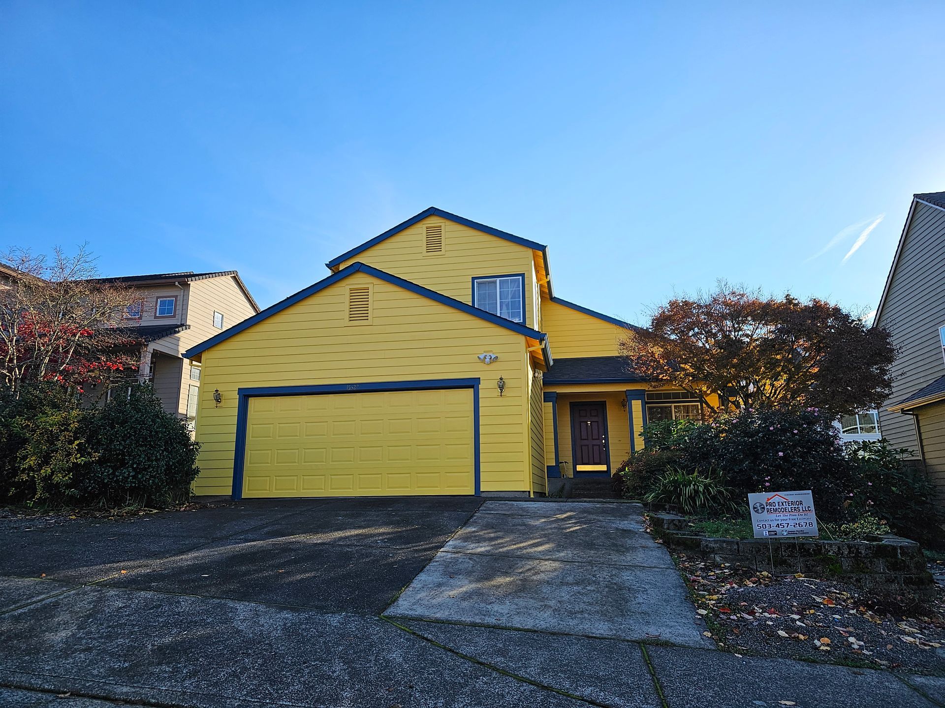 A yellow house with a for sale sign in front of it