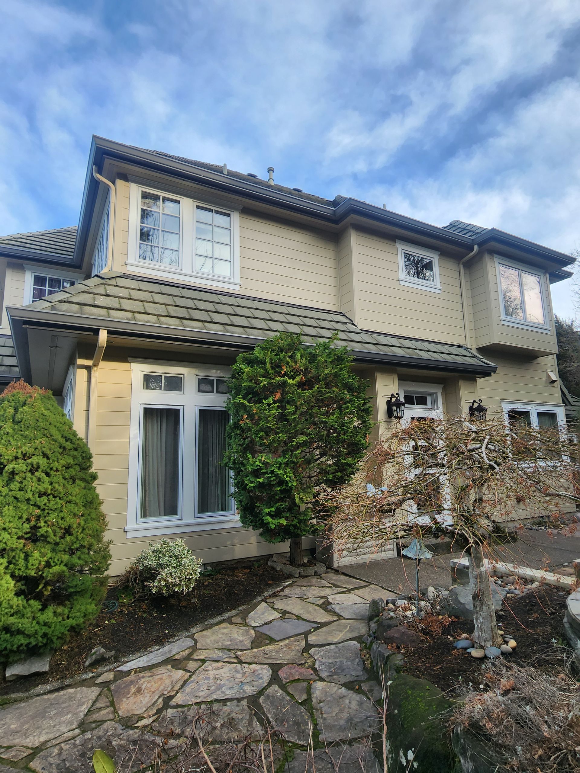 A large house with a lot of windows and a stone walkway in front of it.