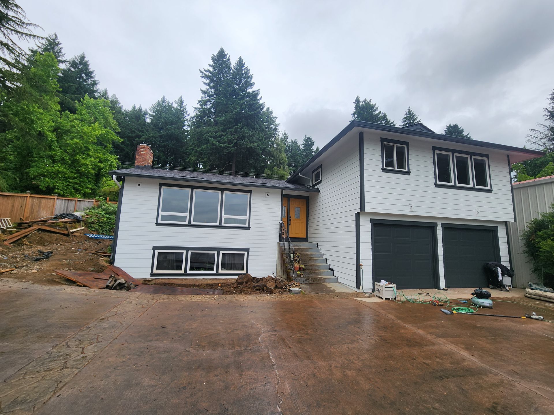 A white house with a black garage and a lot of windows