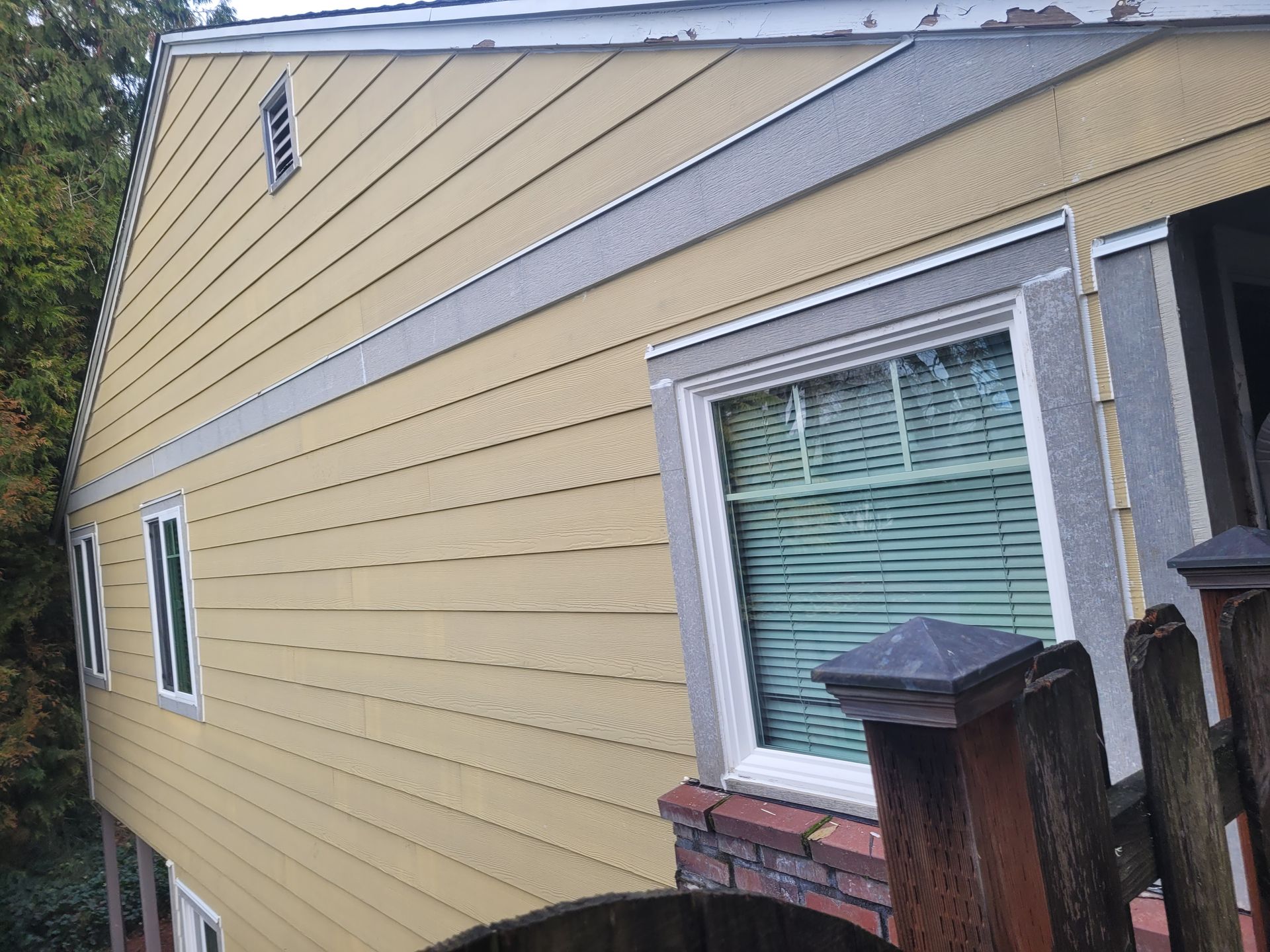 A yellow house with a fence in front of it