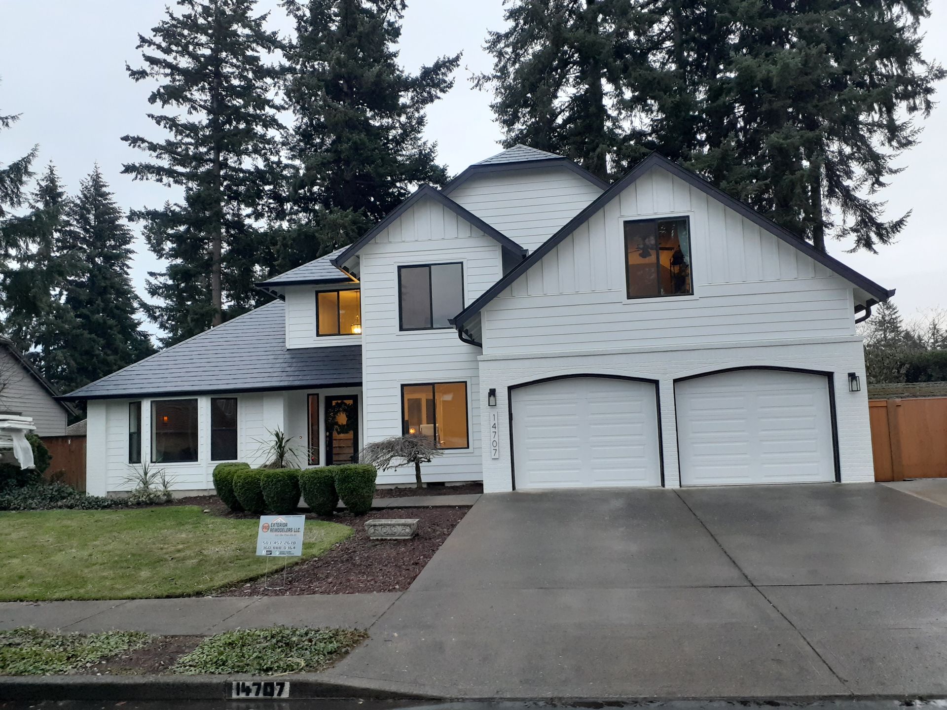 A large white house with two garages and a driveway