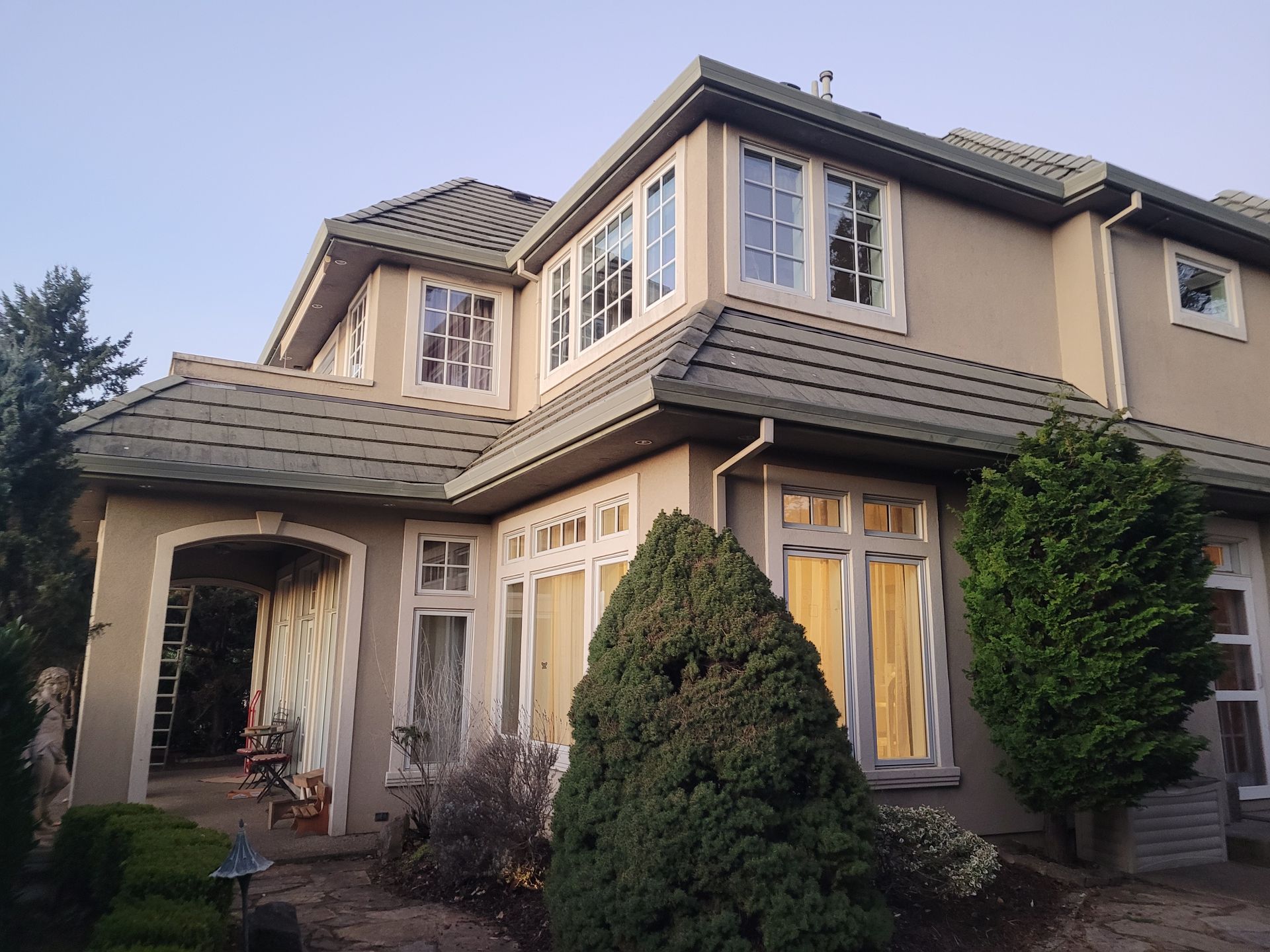 A large house with a lot of windows and trees in front of it