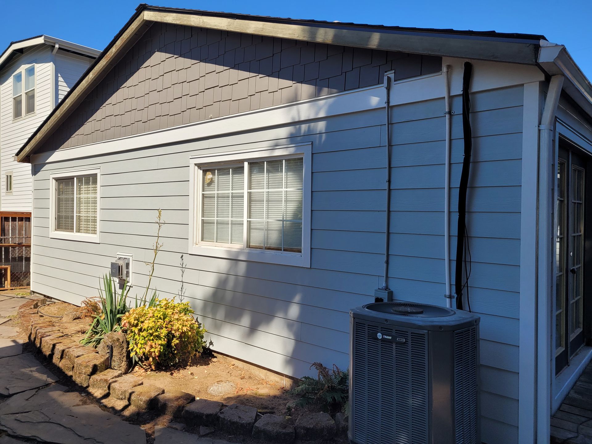 A small house with a air conditioner on the side of it