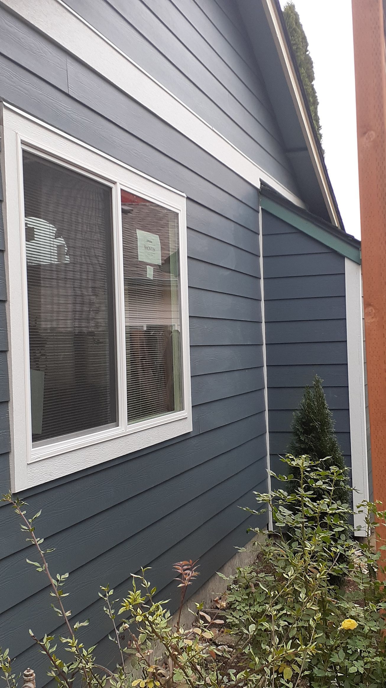 A blue house with a white window on the side of it.