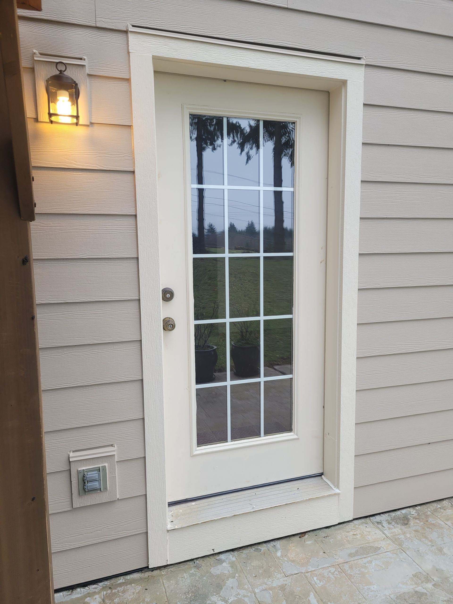 A white door with a light on the side of it