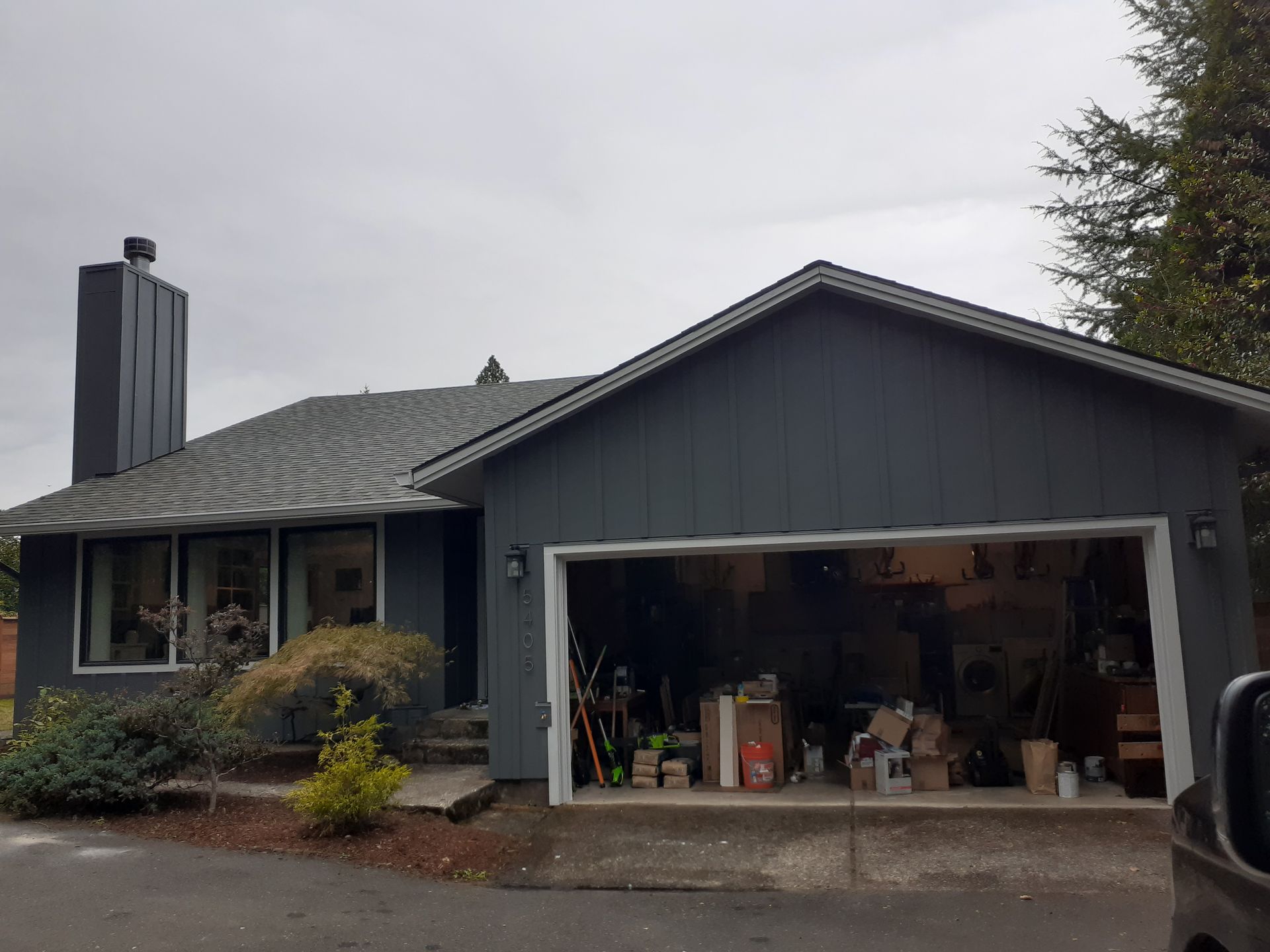 A house with a garage and a car parked in front of it.