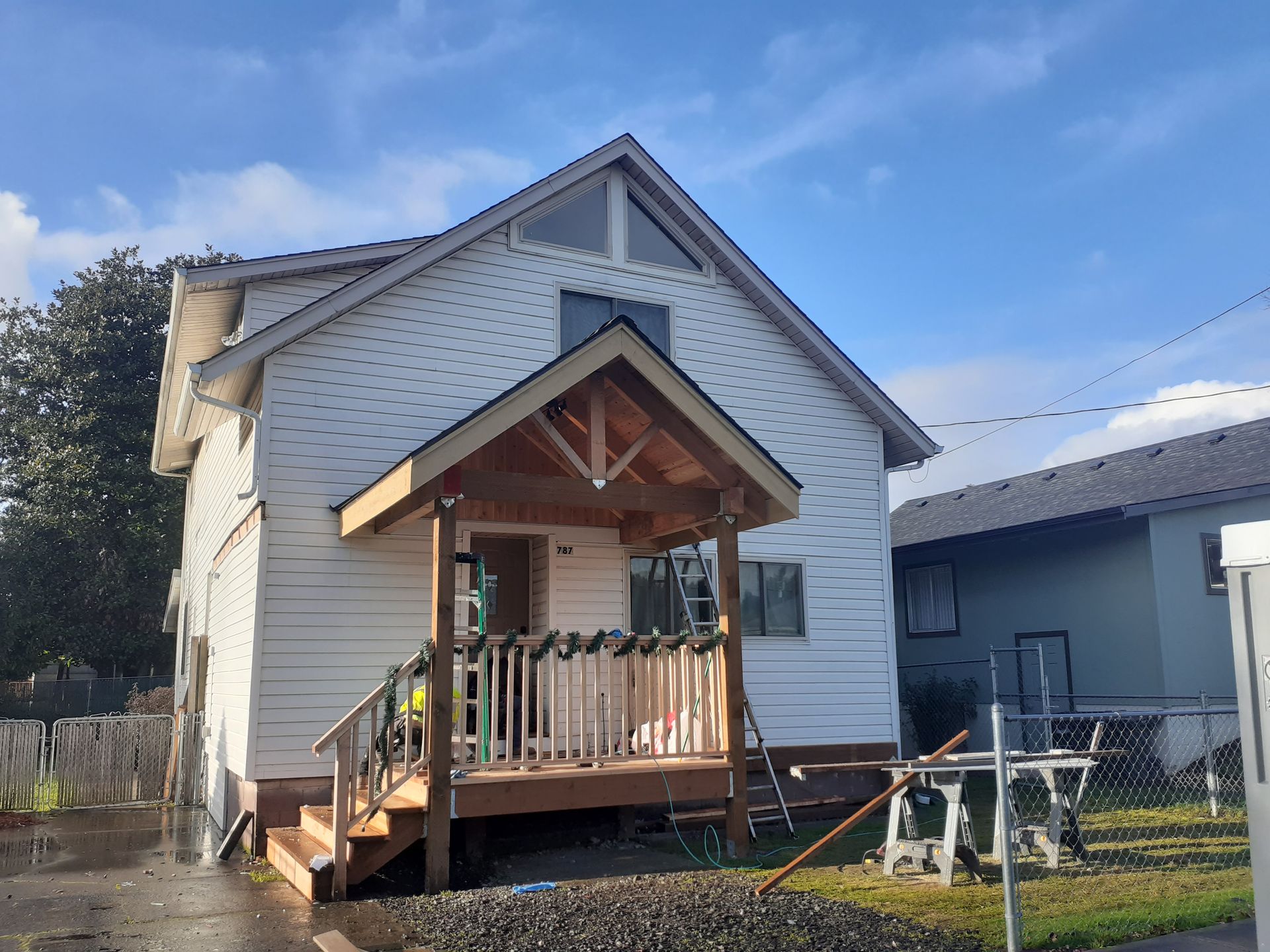 A small white house with a porch and stairs