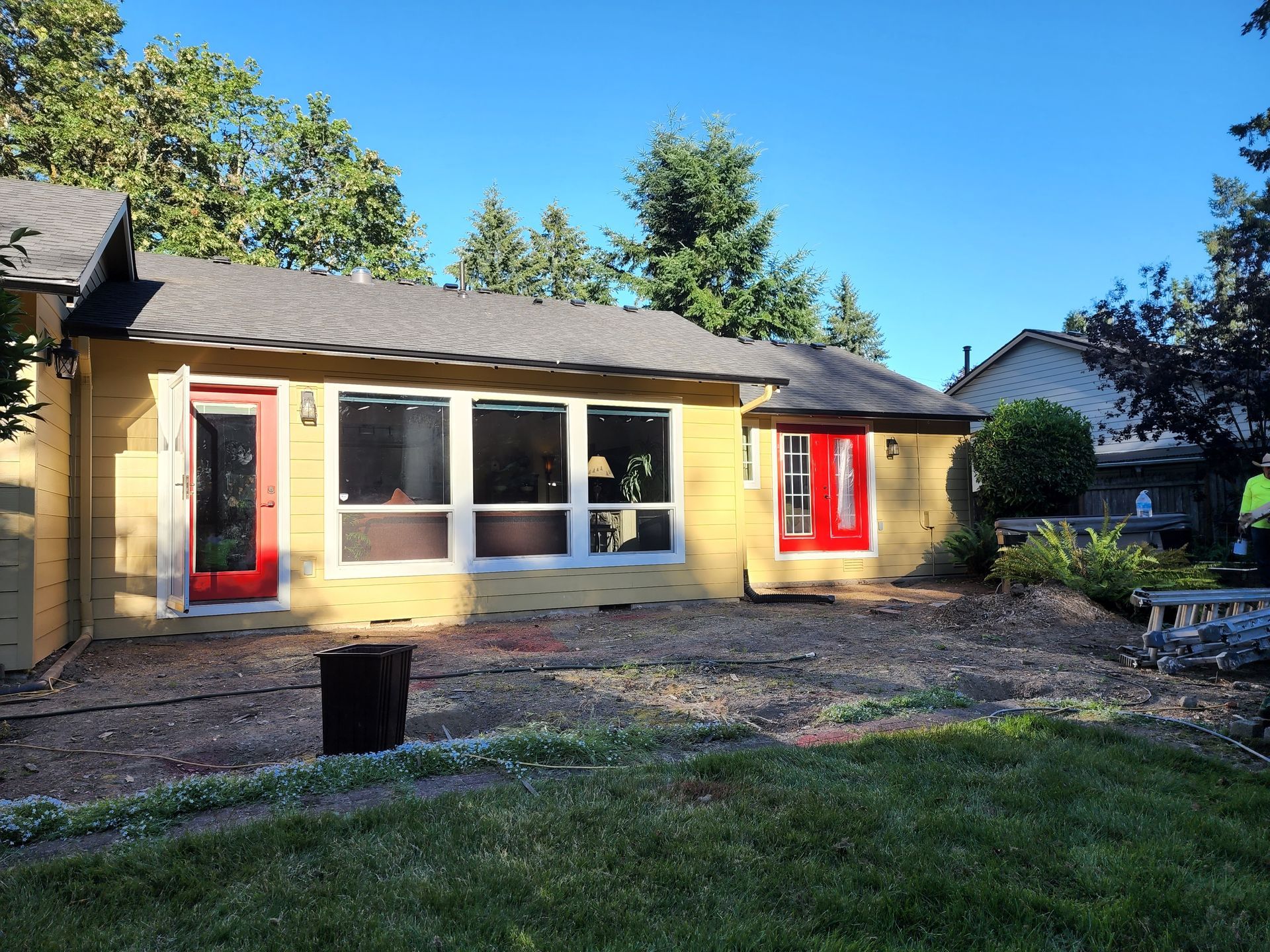 A yellow house with red doors and windows