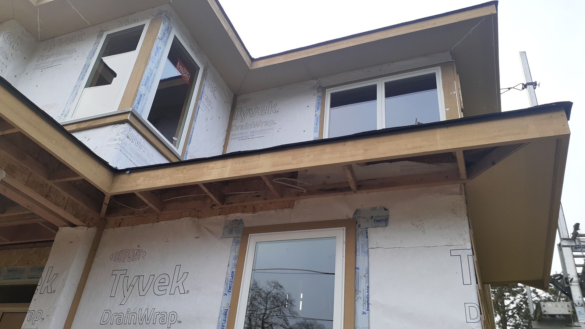 A house under construction with a lot of windows and a roof.
