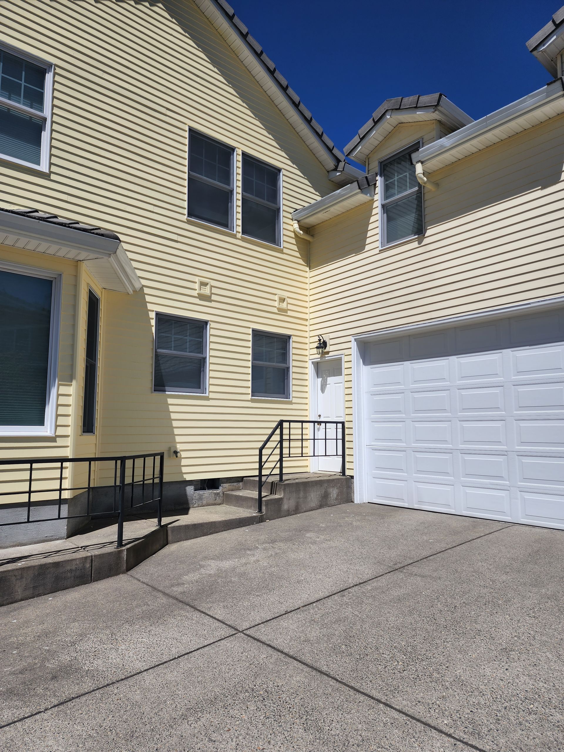 A large yellow house with a white garage door