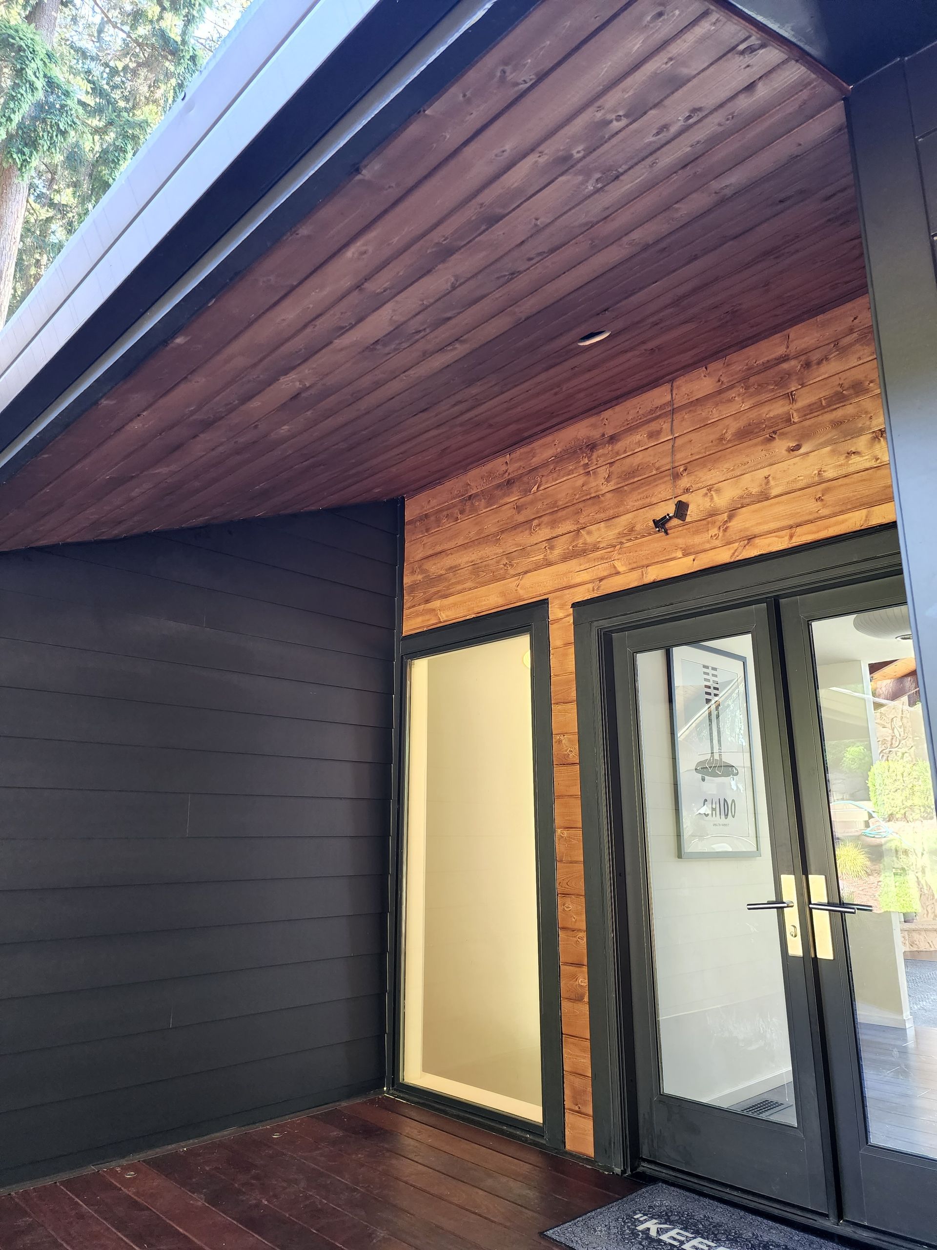 A house with a black door and a wooden ceiling