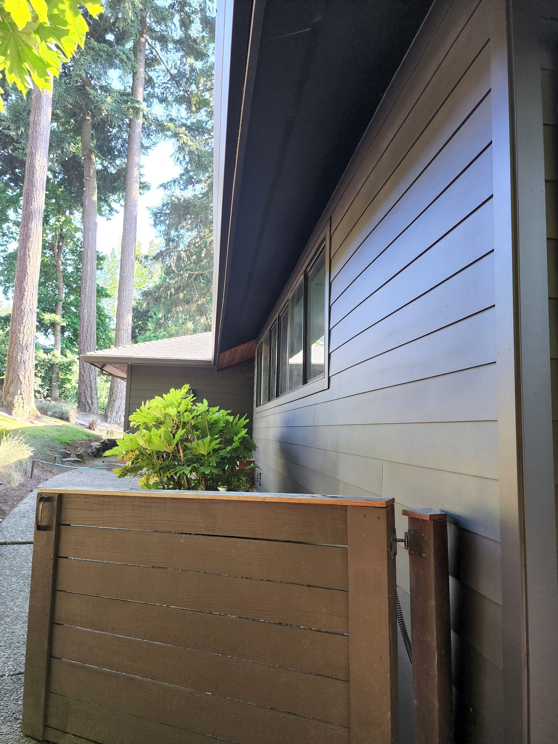 A house with a wooden fence and trees in the background