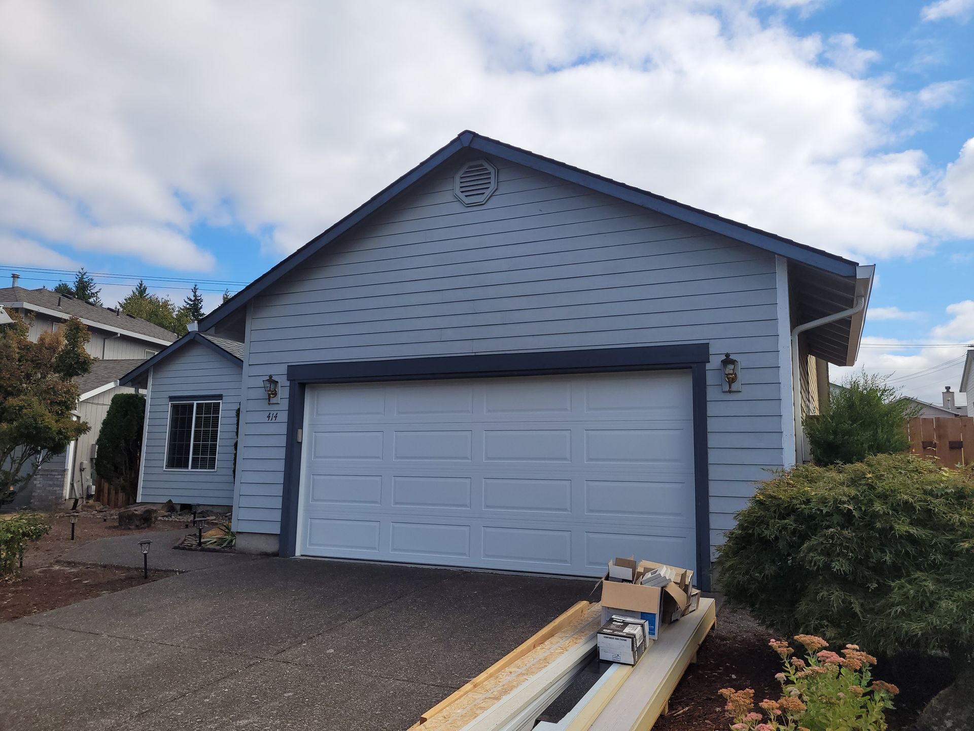 A garage door is being painted in front of a house