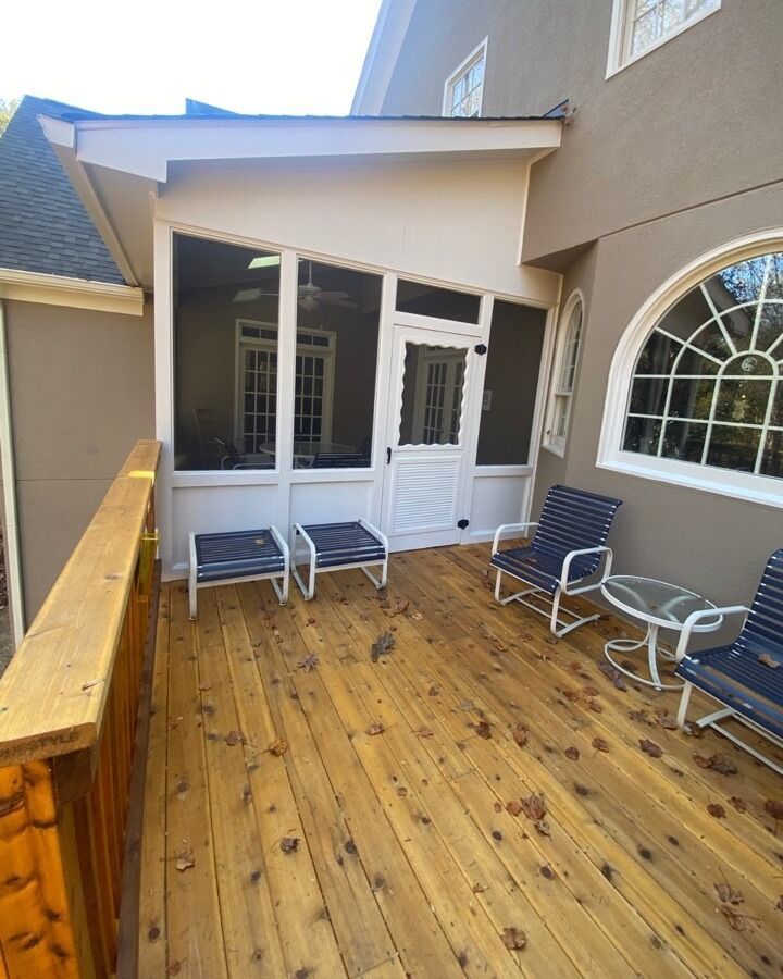 There is a screened in porch with chairs and a table.