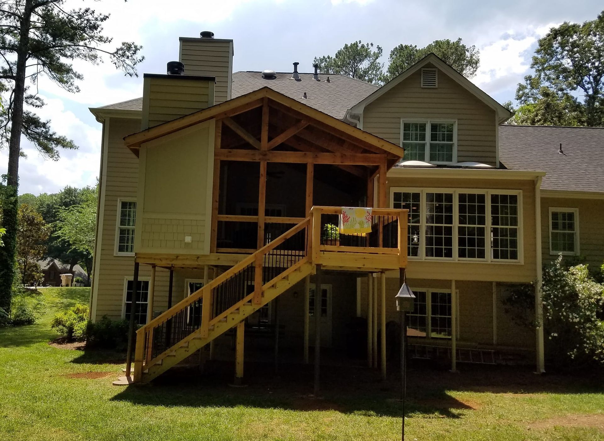 The back of a house with a screened in porch and stairs
