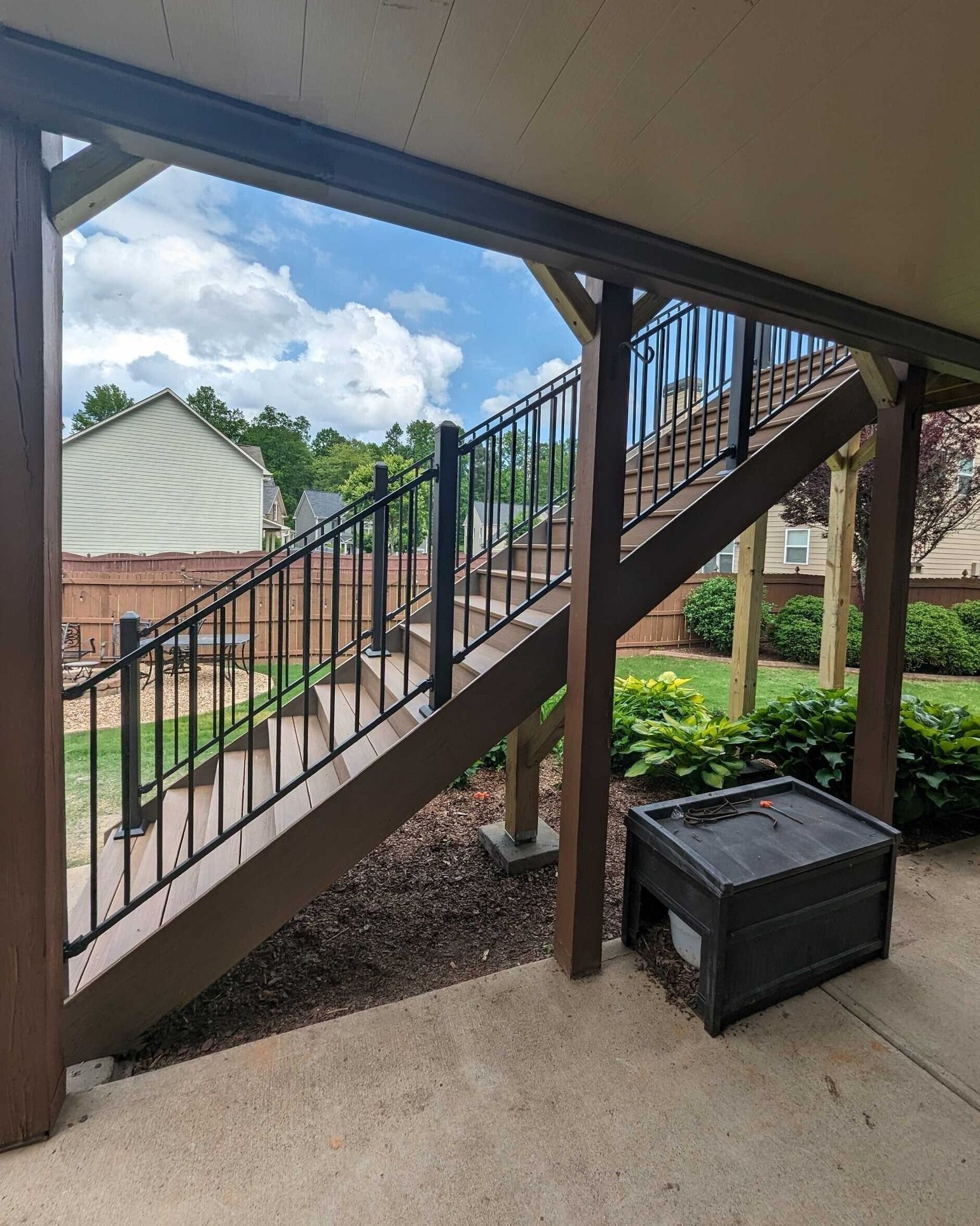 A set of stairs leading up to a deck with a metal railing.