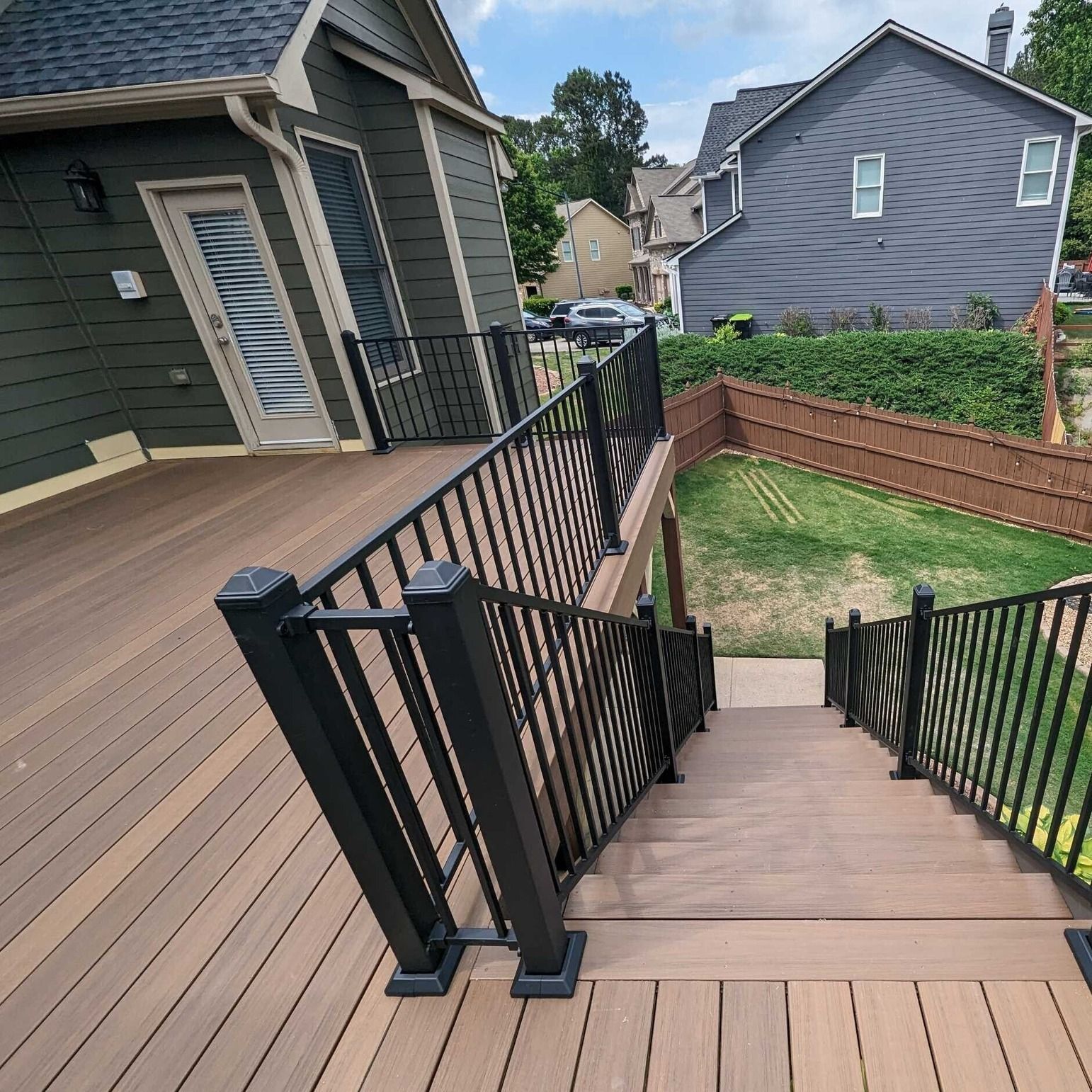 A wooden deck with stairs leading up to a house.