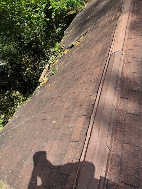 A roof with a shadow of a person on it.