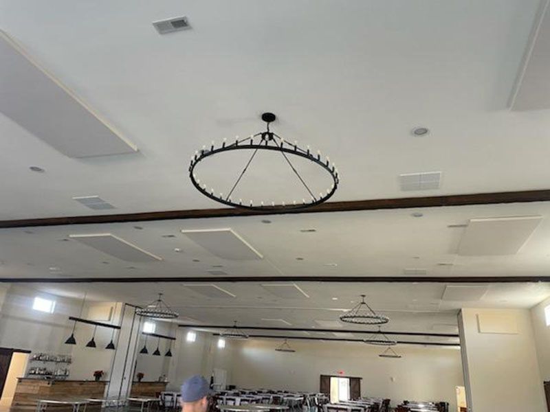 Large, light-filled interior with ring-shaped chandeliers hanging from the ceiling.