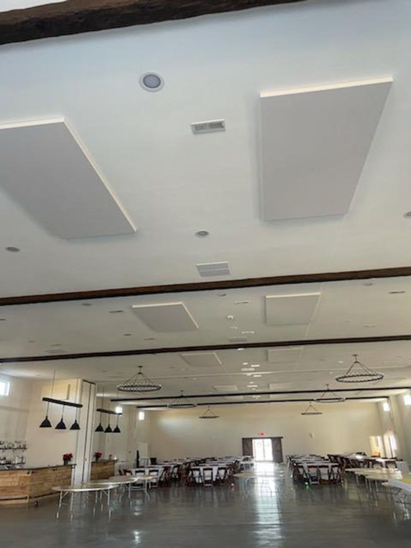 Large, empty event space with high ceiling, tables and chairs, and a bar area.