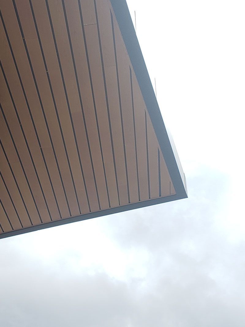 Wooden roof edge against a cloudy sky.