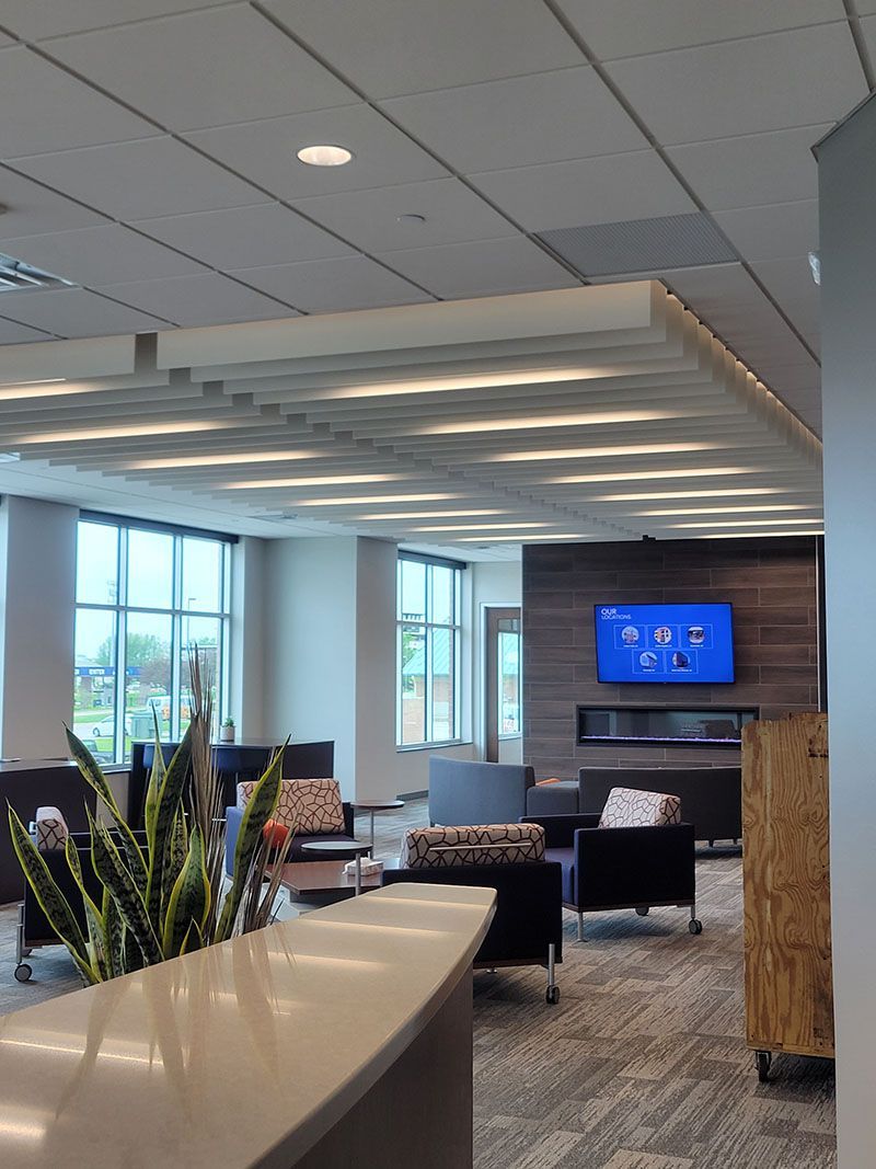 Modern lounge area with seating, fireplace, large windows, and a TV.