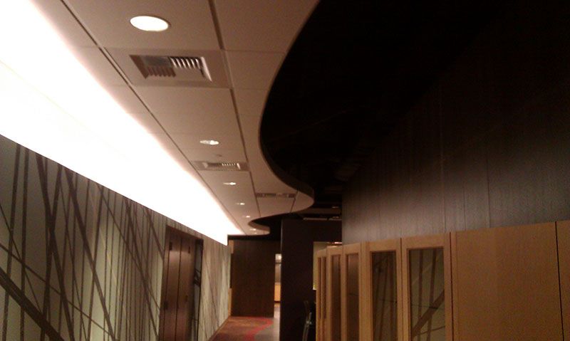 Interior hallway with decorative ceiling lights and a curved wall.