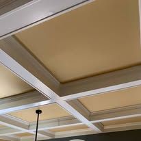 Beige coffered ceiling with white trim and a hanging black light fixture