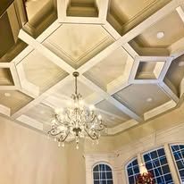 Tray ceiling with chandelier in a cream-colored room above arched windows