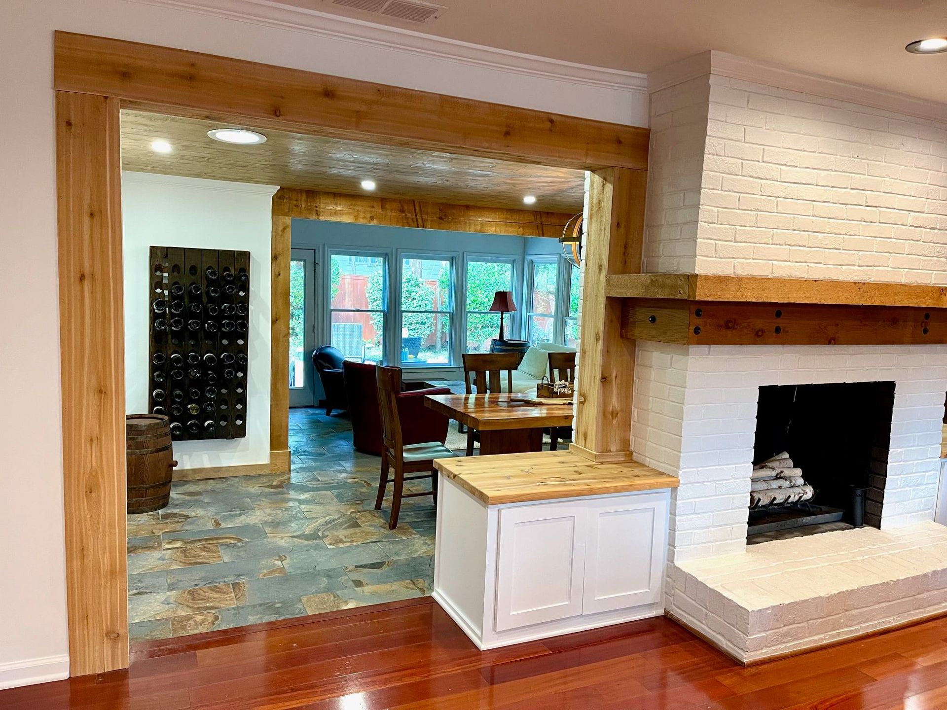 Living room with brick fireplace, wood trim, and a pass-through opening to a dining area