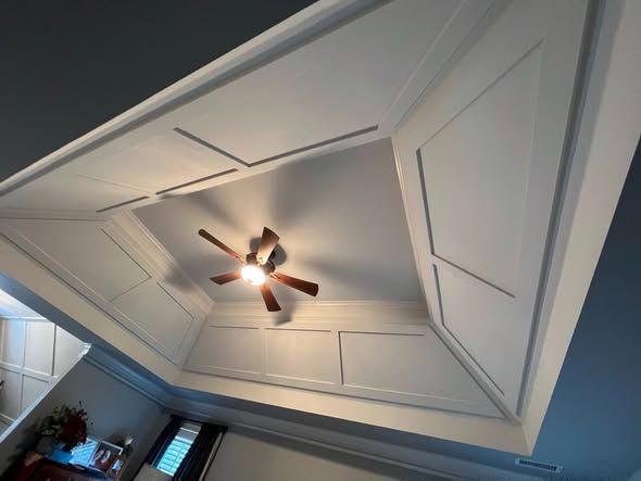 Vaulted white tray ceiling with a ceiling fan and recessed lights in a room