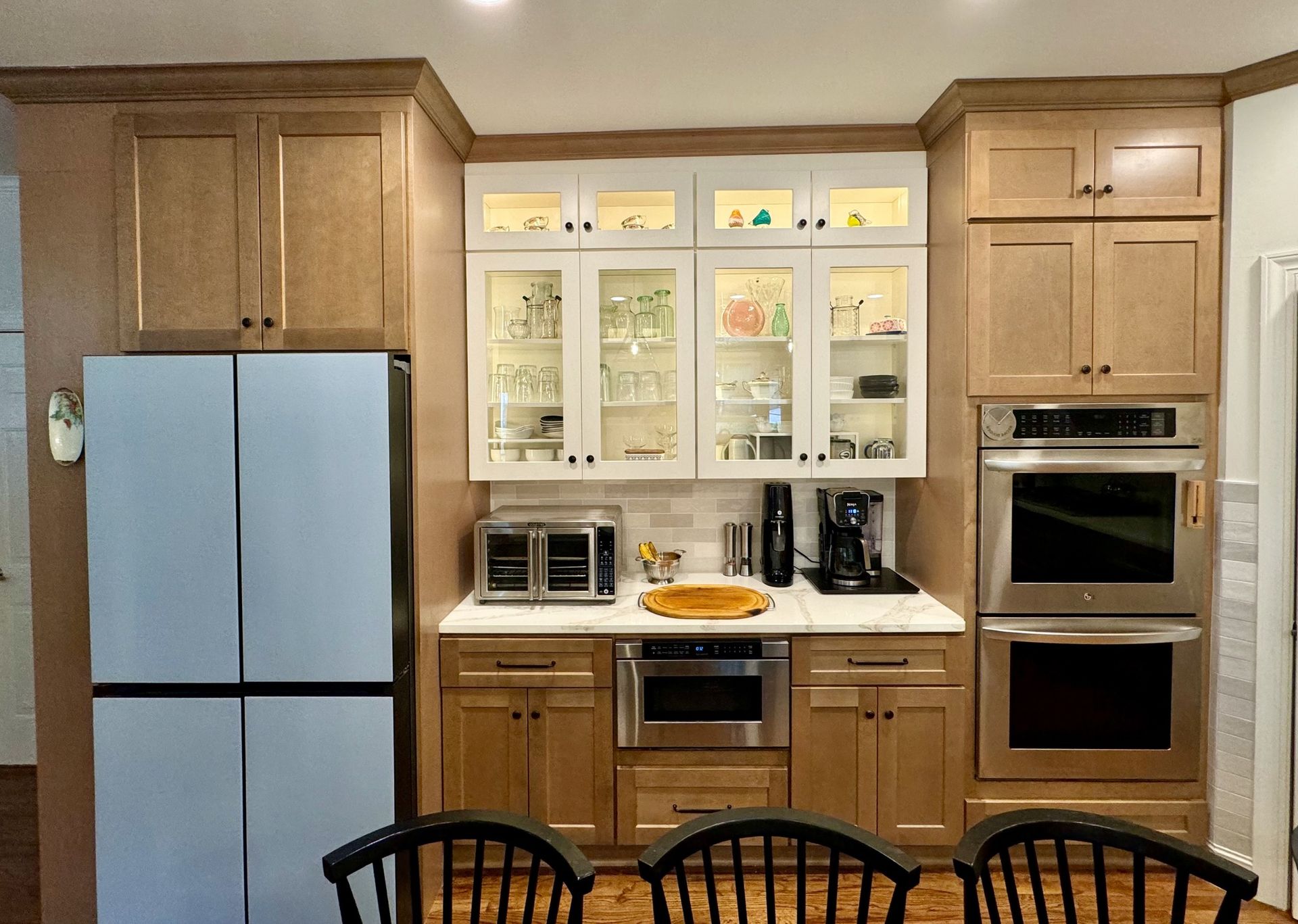 Modern kitchen with wood cabinets, stainless steel appliances, and a dining table in the foreground