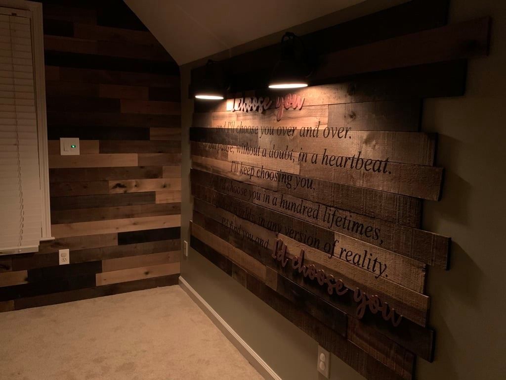 Dim hallway with a wooden slat wall and illuminated text art on the right.
