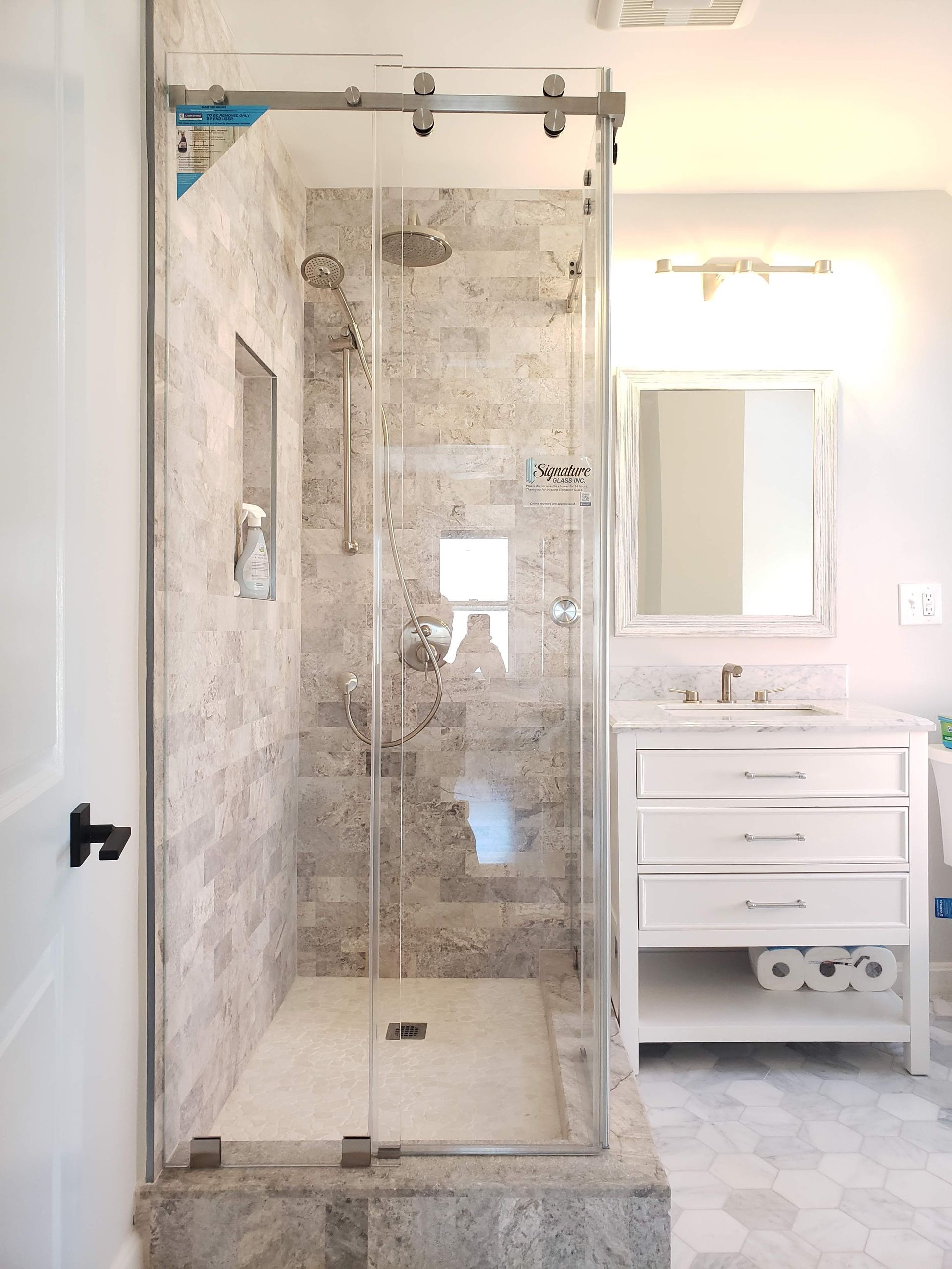 Bathroom with a glass shower enclosure and white vanity.