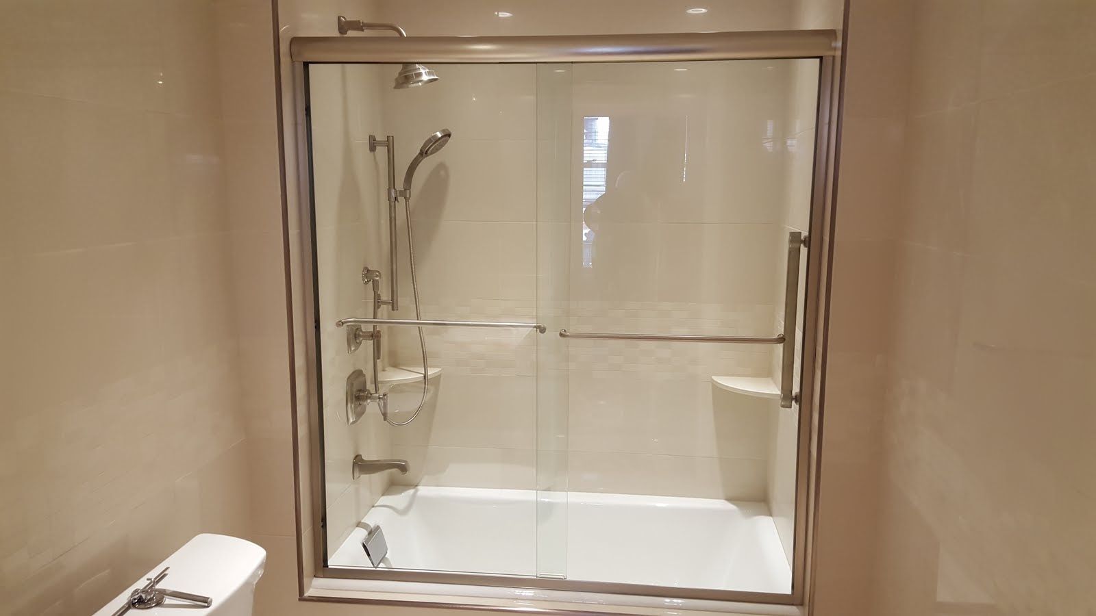 Bathroom with shower and tub, glass sliding doors, white tile, and a toilet.