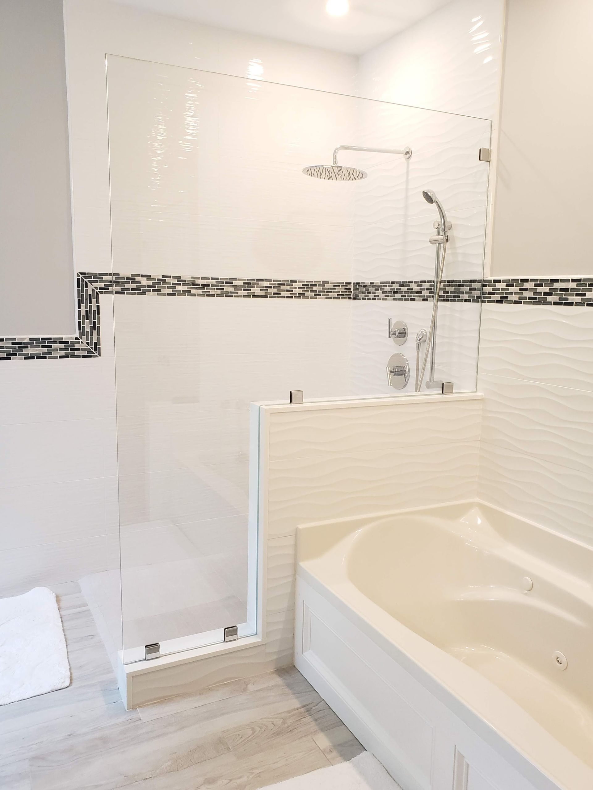 Modern white bathroom with a glass shower enclosure and a built-in tub.