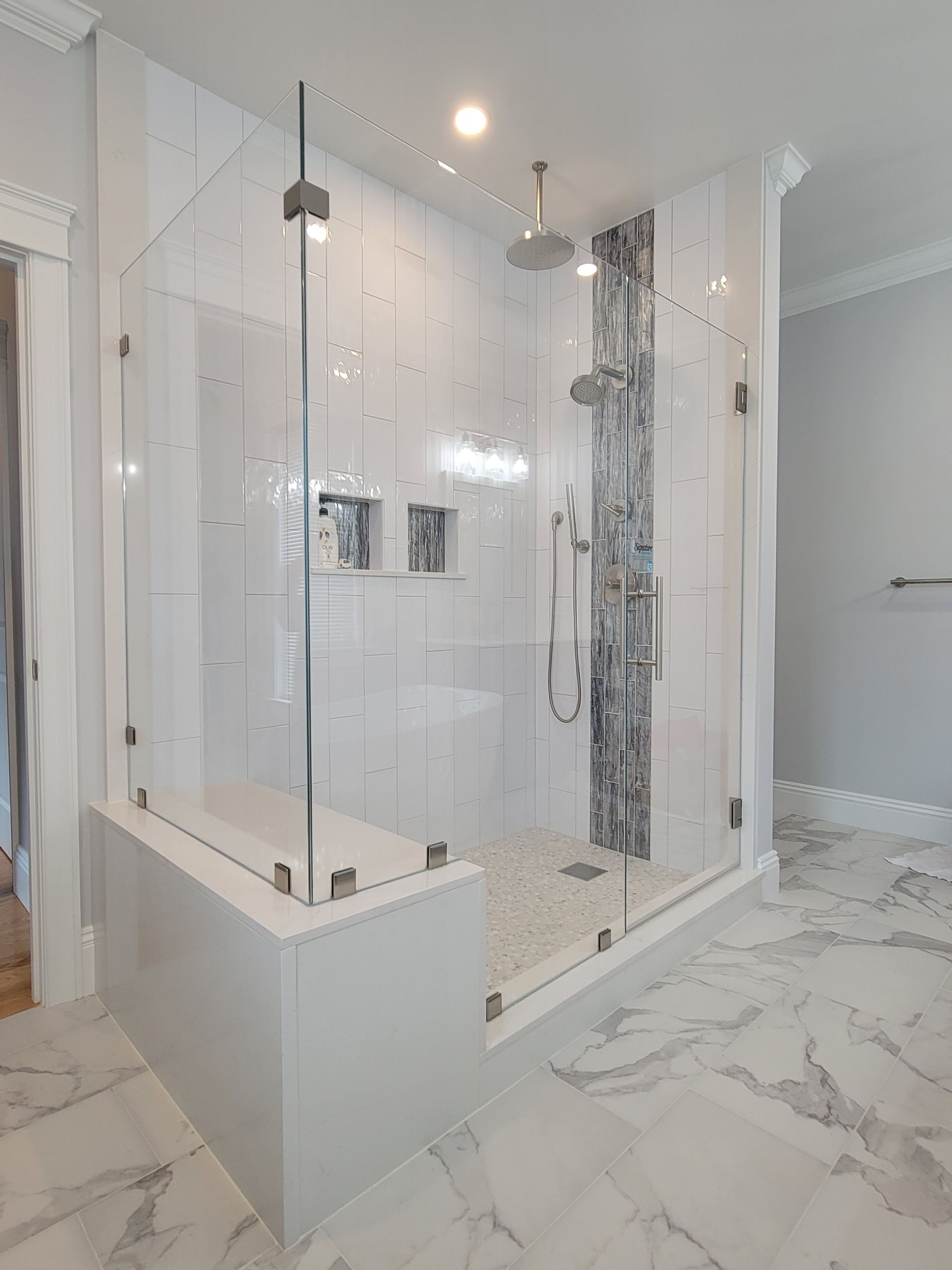 Modern bathroom with marble floors and a glass shower.