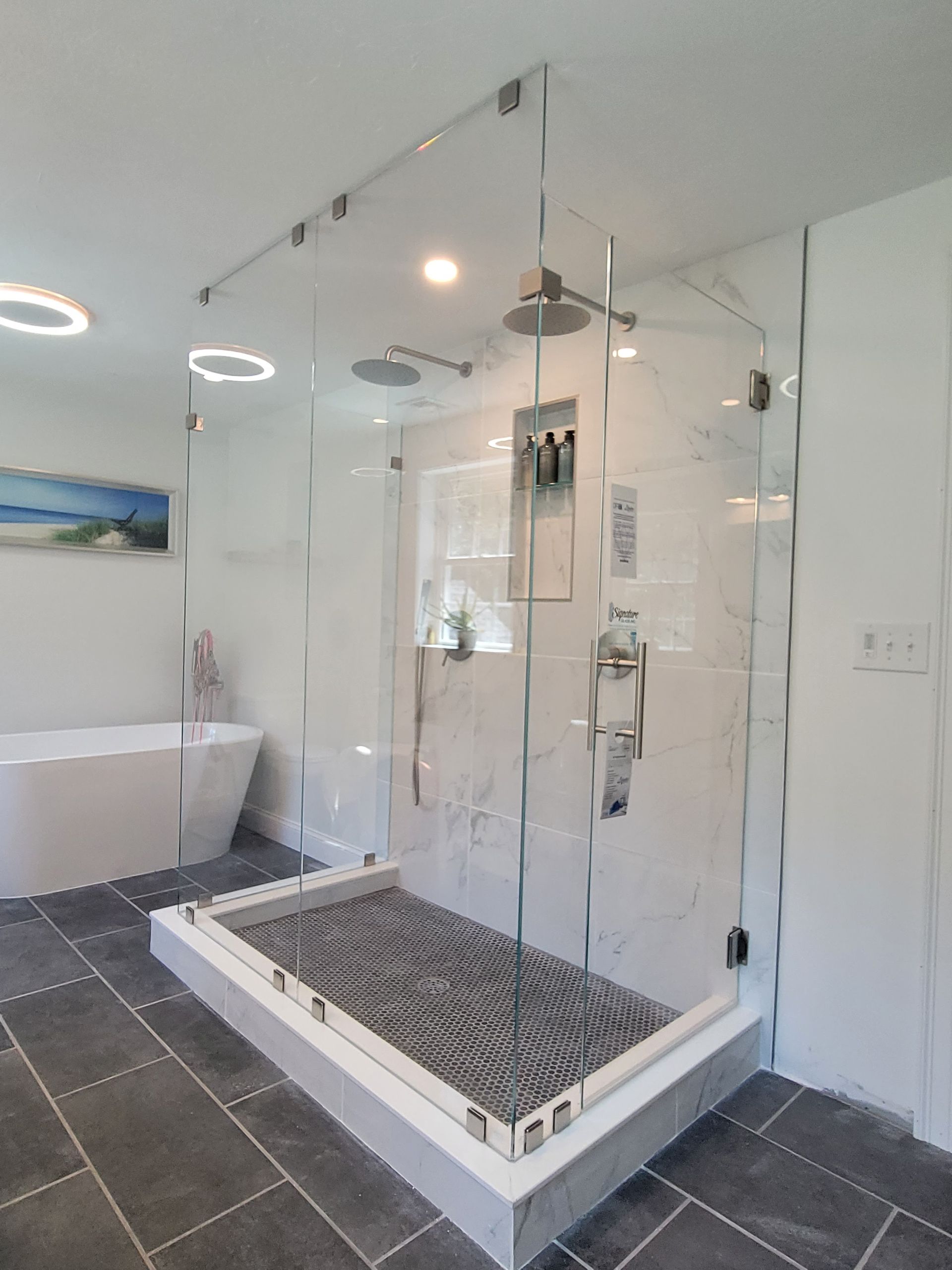 Modern bathroom with a glass shower enclosure and a freestanding bathtub.